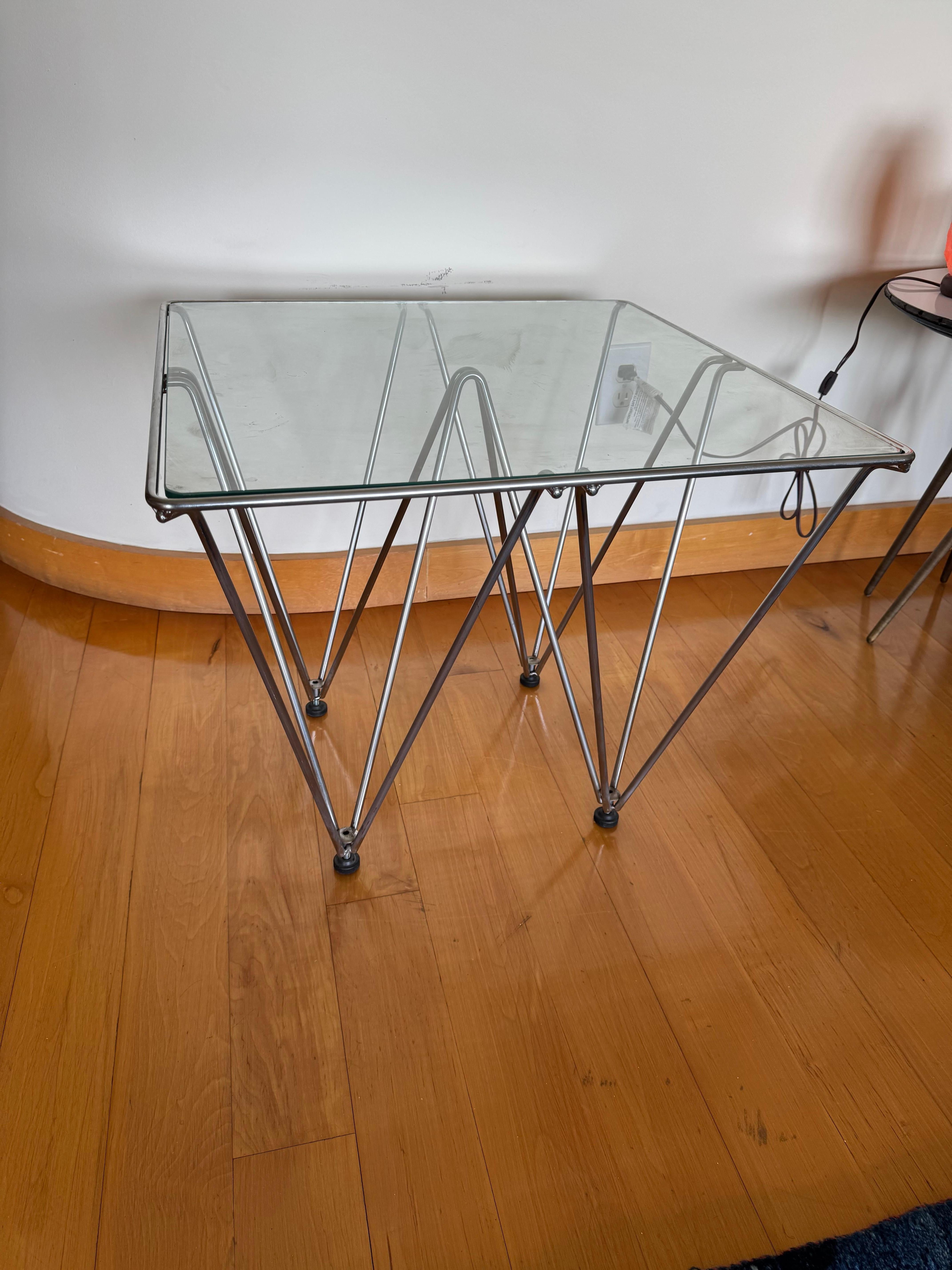 This is a Paola Piva styled coffee table.
Its constructed of a thick guage steel wire shaped into upside down pyramids. It comes with a fitted piece of glass that gives it the effect of the Louve. 

its a very sculptural and artsy piece.
 
