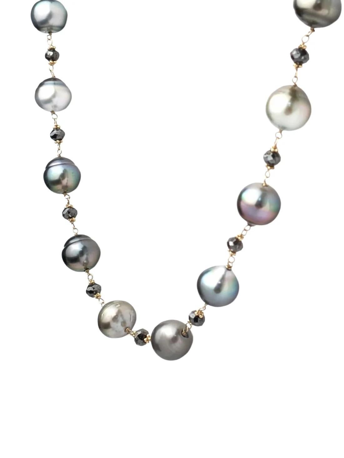 Un jeu d'ombres et de lumières saisissant. Ce collier présente des perles rondes de Tahiti dans différentes nuances de gris argenté, chacune sélectionnée pour son éclat et sa tonalité. Les perles sont reliées à la main à des perles de diamant noir