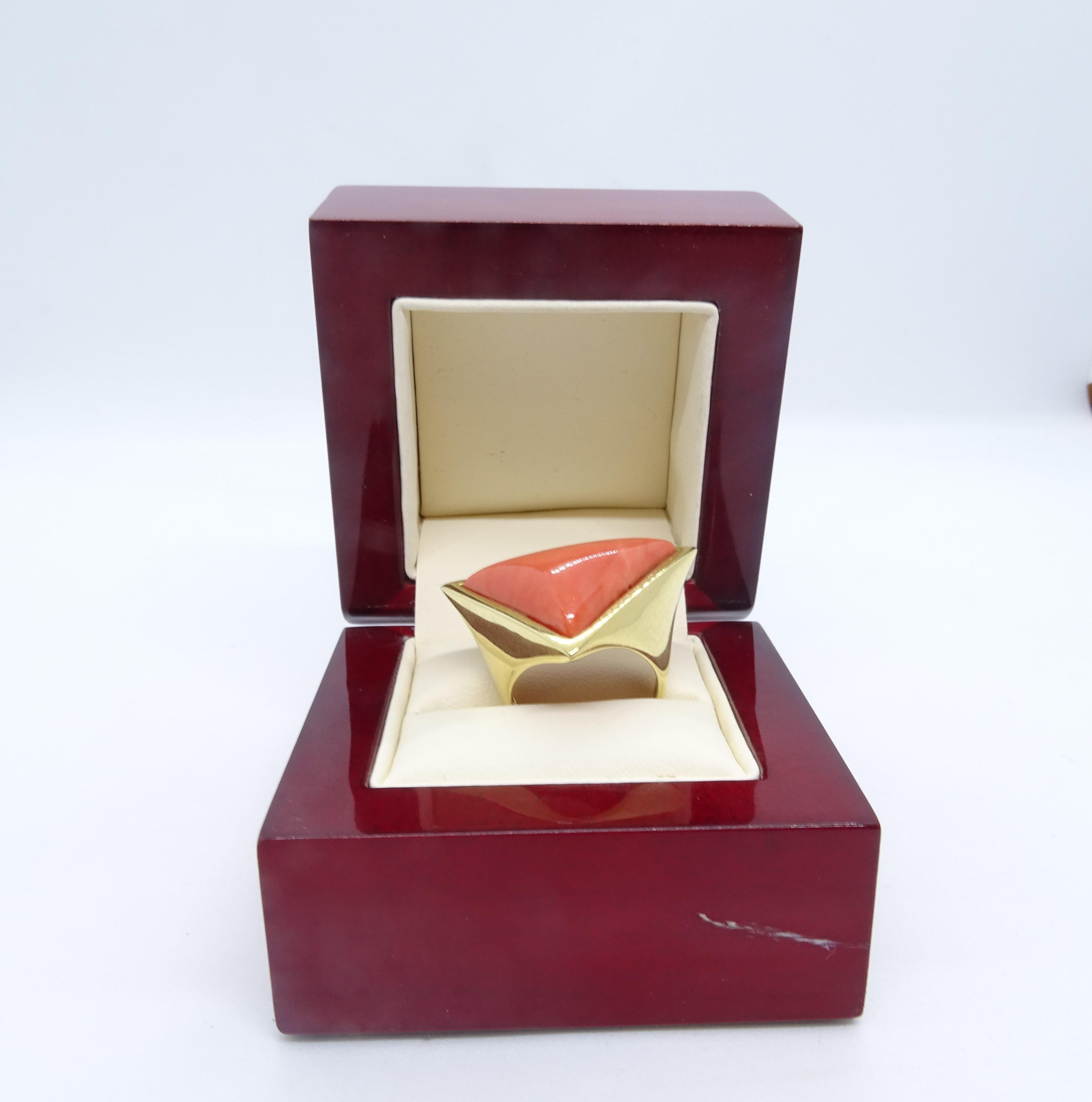 Exquisite 18-carat gold ring and a precious angel skin coral cabochon with a triangular profile.

It is an Italian ring with a contemporary design. The main stone is inscribed in an isosceles triangle formed by the very base of the jewel.

The total
