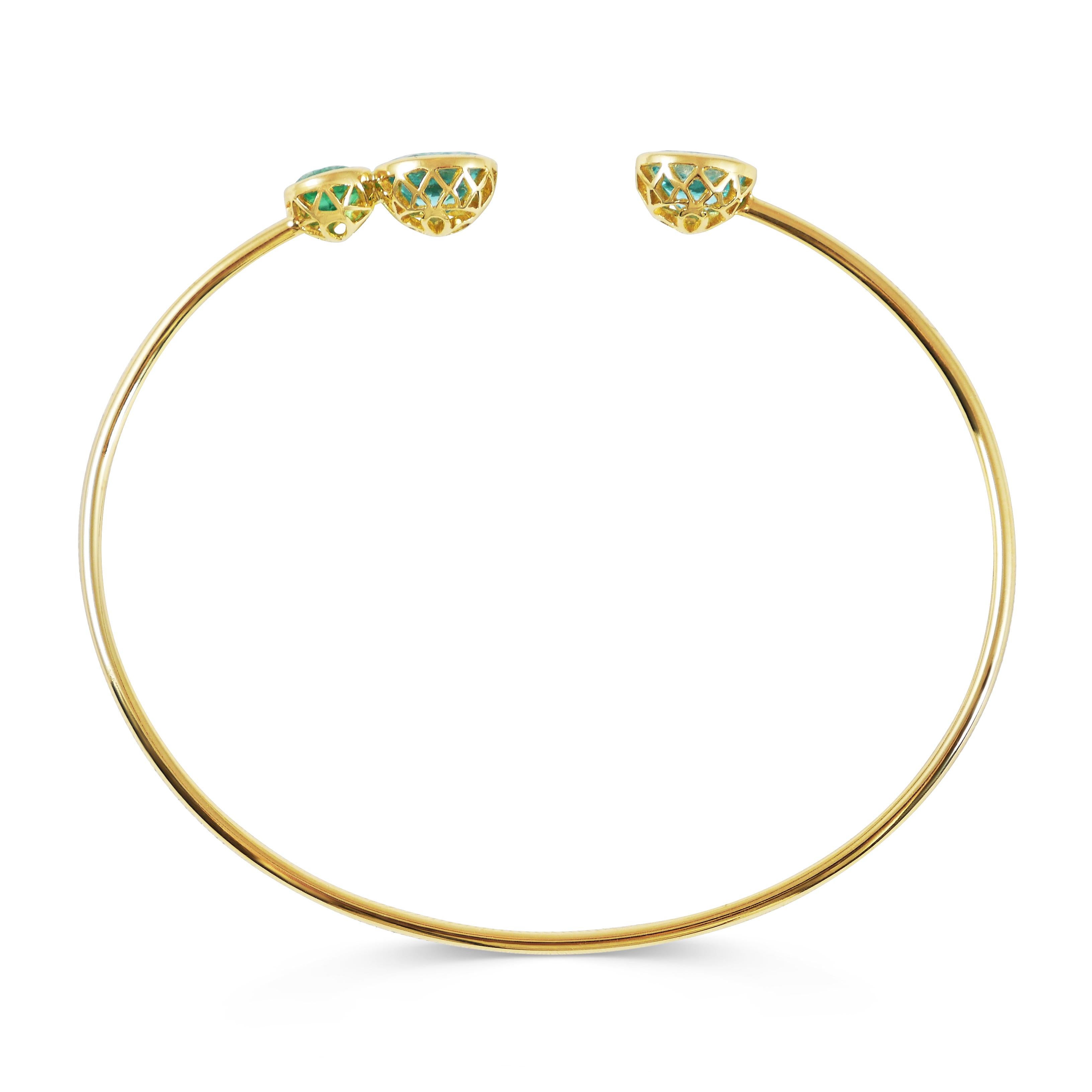 Handcrafted 2.00 & 0.55 Carat Apatites & Emerald 18k Yellow Gold Open Bangle Bracelet. Designed as birds singing next to one another this bracelet combines a colorful range of precious gems. Our signature hand pierced lace on the back of each gem