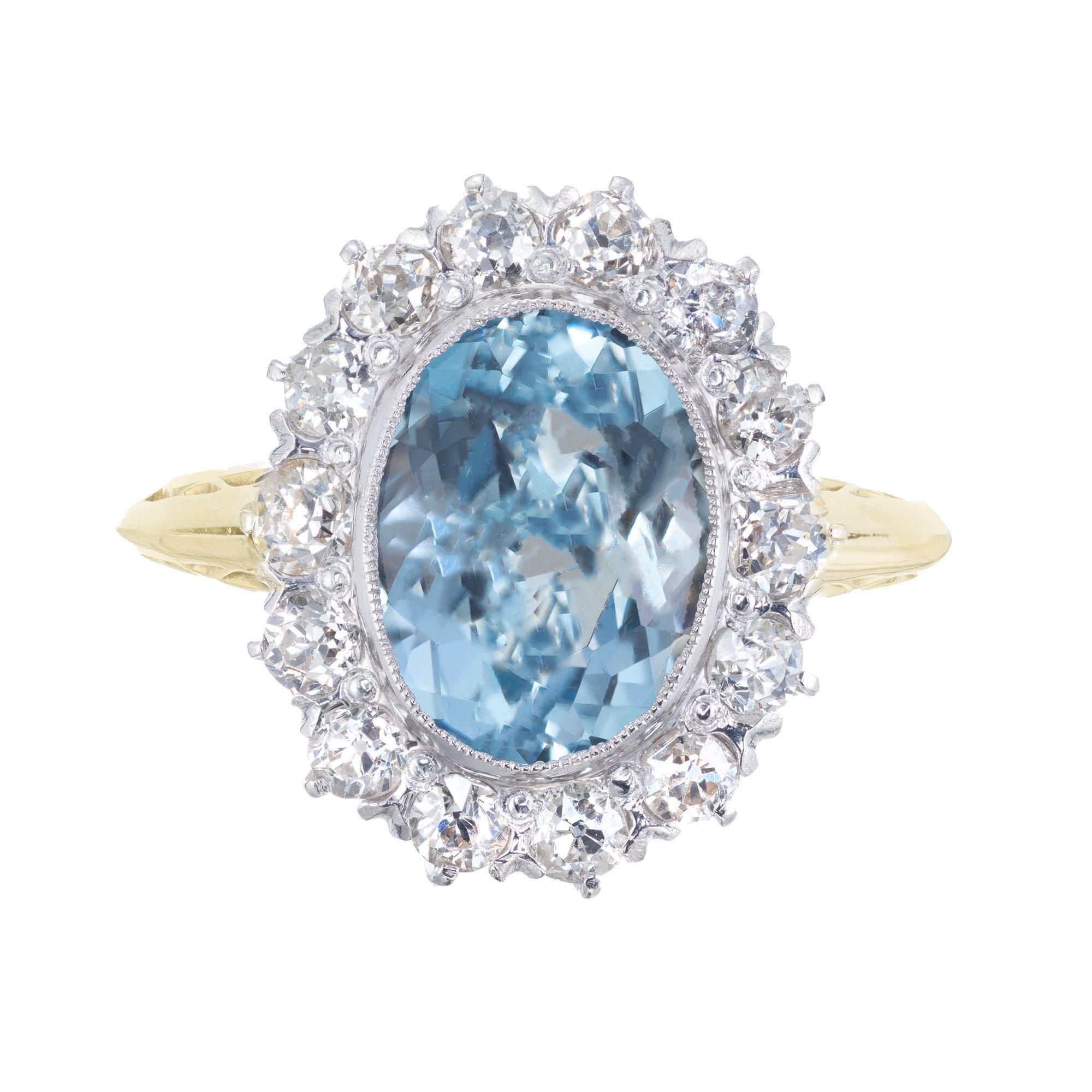 1930's Art Deco Oval aquamarine center stone with a halo of 14 old European cut accent diamonds in a 14k yellow and white gold setting. 

1 oval blue Aquamarine, approx. 2.00ct
14 old European cut diamonds I-J SI-2, approx. .42cts
Size 4.75 and