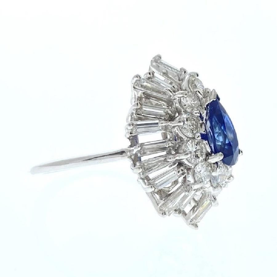 This exquisite ring features a stunning 2-carat blue pear-shaped sapphire, renowned for its deep, captivating hue. The sapphire is elegantly framed by a halo of 30 round diamonds, totaling 2.50 carats, which accentuate its vibrant color and