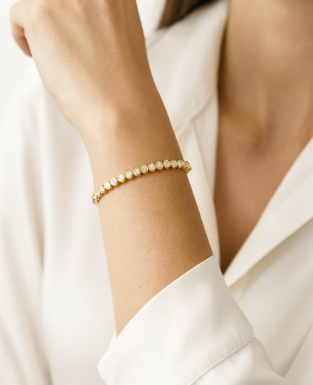 This classic diamond tennis bracelet is a timeless design that never goes out of style. Crafted in rich 18k yellow gold with a weight of 13.5 grams, it features a continuous line of round brilliant cut diamonds totaling 2.00 carats.

The diamonds