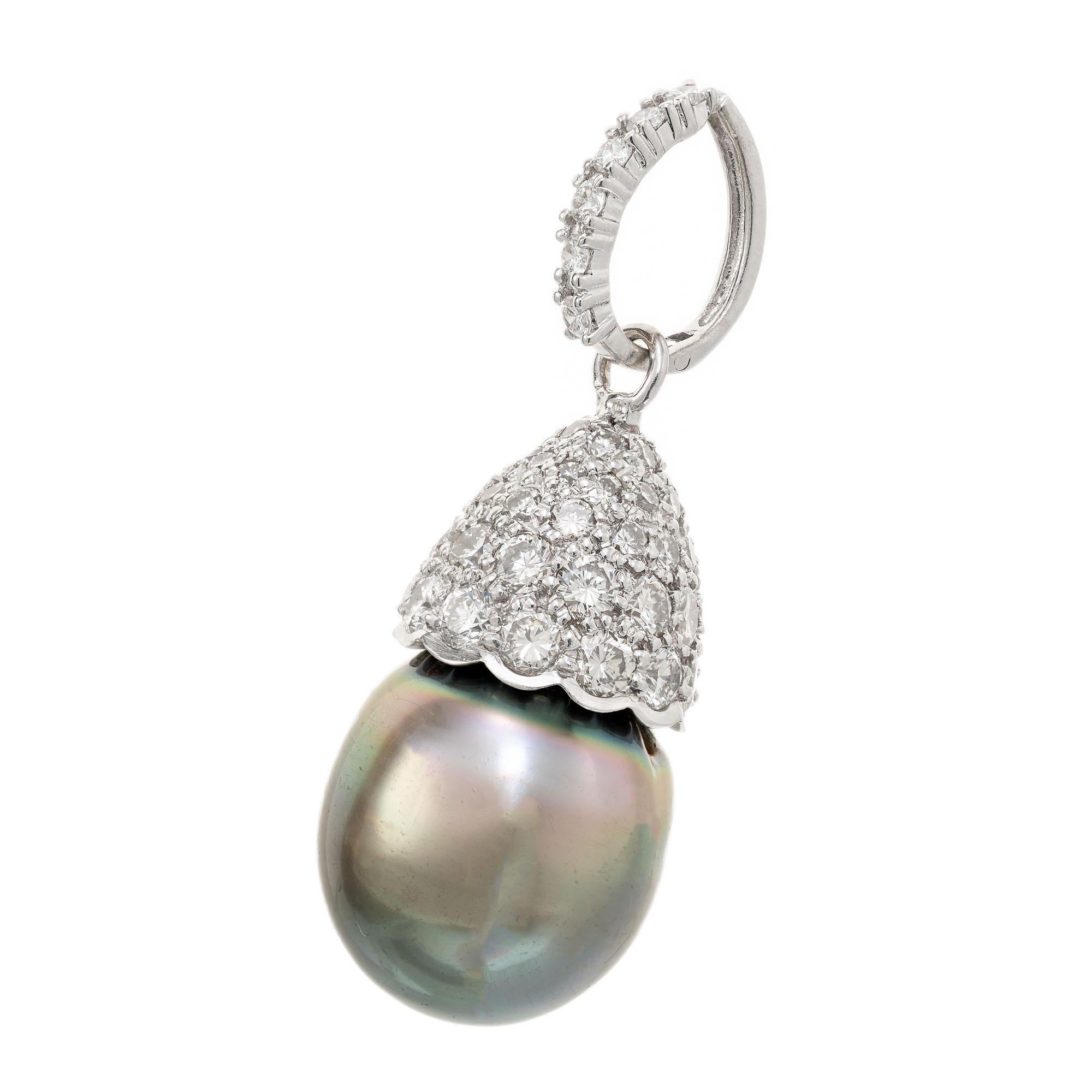 Grey South Sea pearl with a diamond cap and hinged enhancer top set with two carats of bright round brilliant cut diamonds.

60 round brilliant cut diamonds, G-H SI approx. 2.00cts
1 South Sea grey pearl, good lustre, few blemishes 13.2mm x 16mm
14k