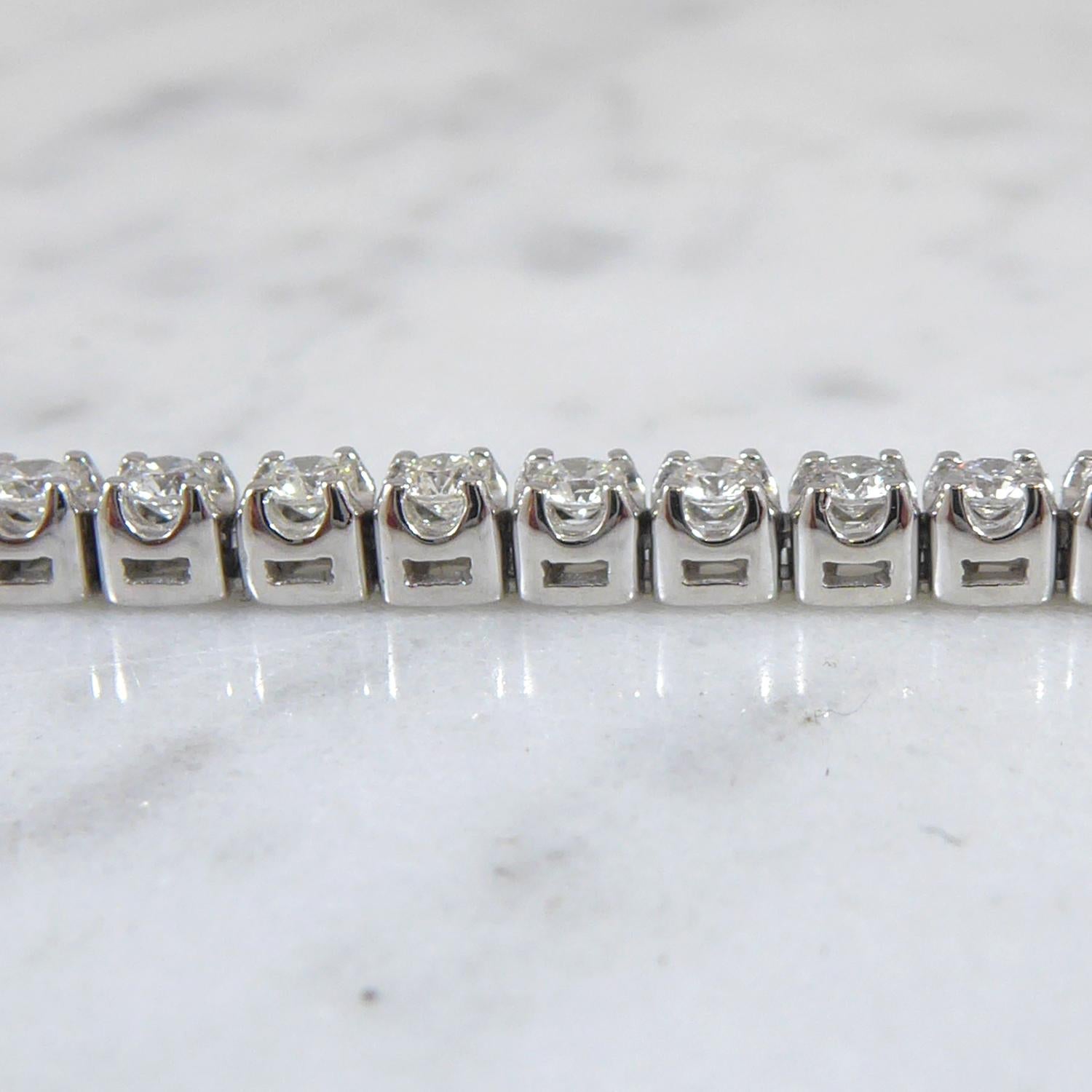 A modern classic, the diamond tennis or line bracelet.  This version comprises 61 round brilliant cut diamonds totalling 2.0ct. claw set in platinum.  Fastening with a V spring catch and two figure-of-eight safety clips.  Approx. 7.25 inches long. 