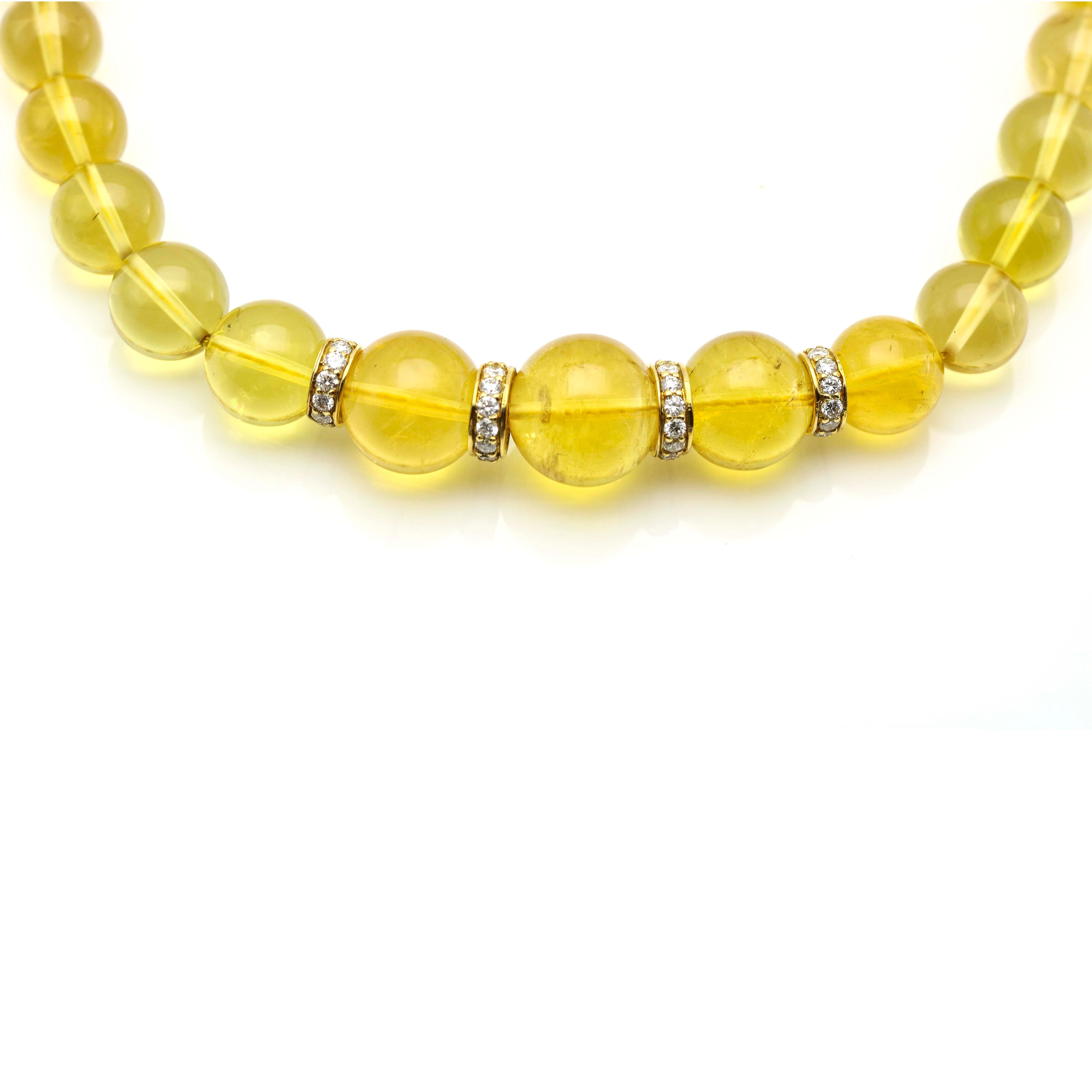 Graduated beryl bead necklace with large slide clasp encrusted with diamonds in 18 karat yellow gold. The necklace has 4 spacer beads pave set with round diamonds. Length, 18 inches. Beads, 15mm to 9mm. Weight, 91.4 grams. Diamond carat total