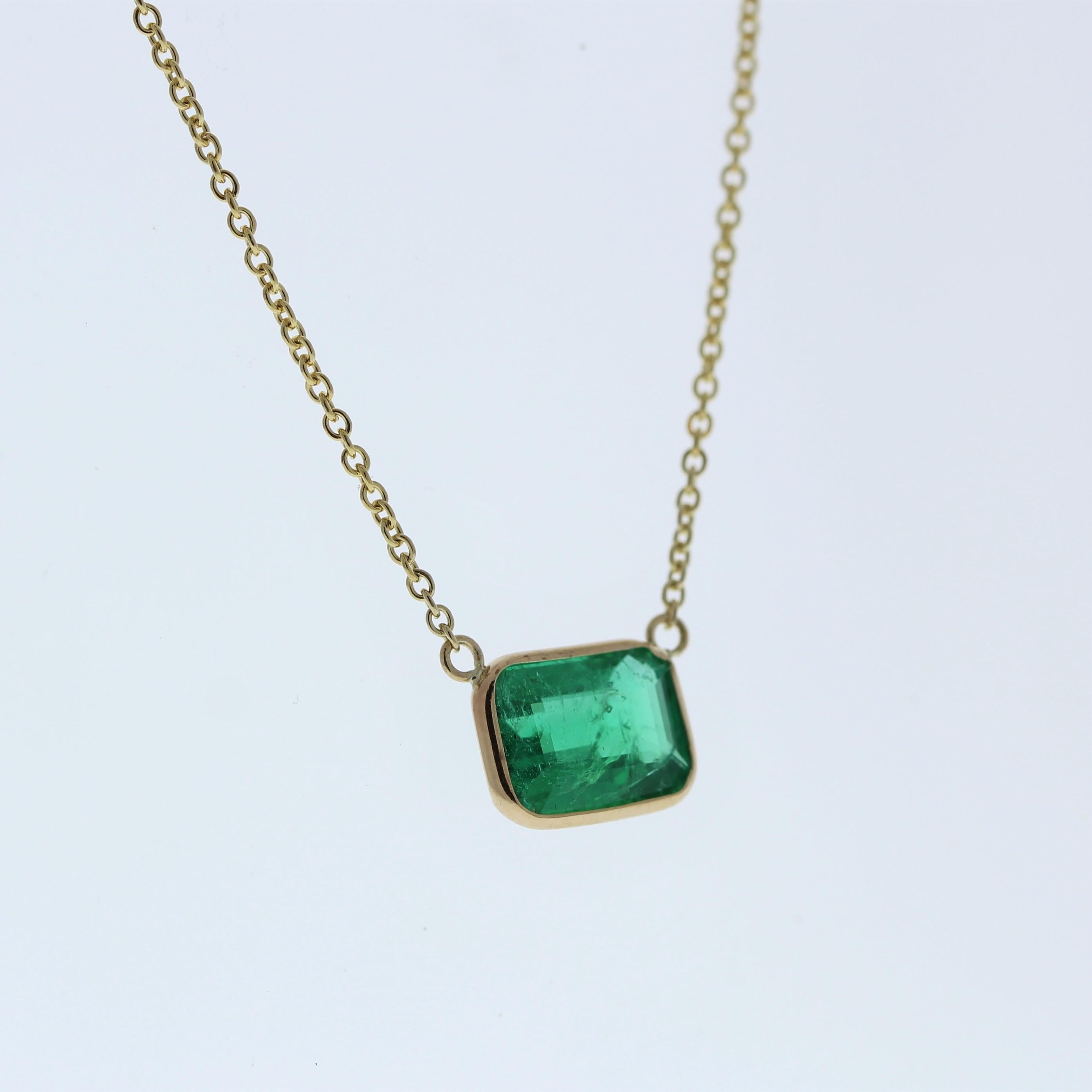 The necklace features a 2.00-carat emerald-cut emerald set in a 14 karat yellow gold pendant or setting. The emerald cut and the lush green color of the emerald against the yellow gold setting are likely to create an elegant and eye-catching fashion
