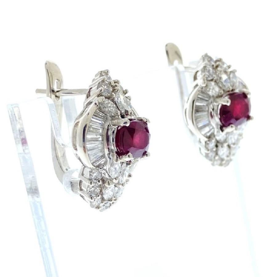 Paré de l'élégance intemporelle de ces exquises boucles d'oreilles, chacune ornée d'un captivant rubis de 2 carats de forme ovale. Autour de chaque rubis vibrant, 64 diamants brillants, d'un poids total de 2,50 carats, ajoutent un éclat exceptionnel