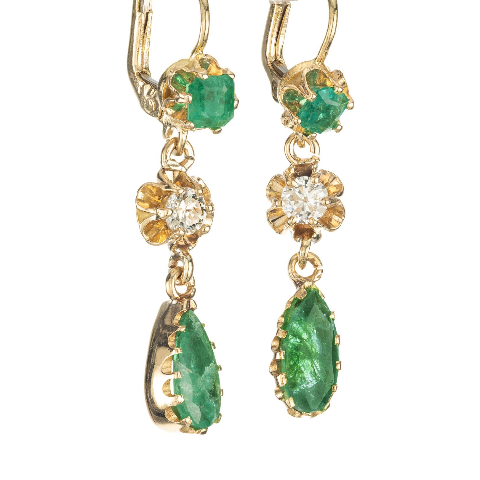 Boucles d'oreilles pendantes en or jaune 14k du milieu des années 1960, ornées d'émeraudes naturelles et de diamants taillés en brillant. Serti de 2 émeraudes vertes rondes dans une monture de style couronne avec 2 émeraudes en forme de poire