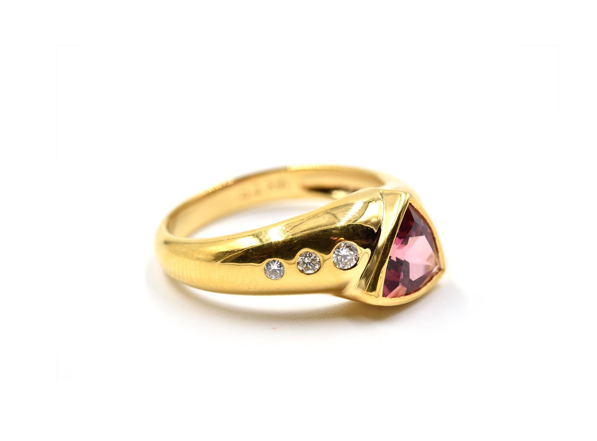 Designer: custom design
Material: 18k yellow gold
Pink Tourmaline: one 2.00 carat trilliant cut pink tourmaline 
Diamonds: 0.07 carat weight
Dimensions: ring top is 1/4-inch long
Ring Size: 6 1/2 (please allow two additional shipping days for sizing