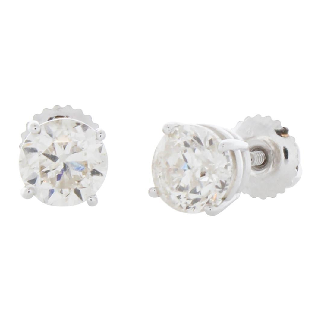 Stunning 14 Karat white gold handmade earrings featuring 2 round brilliant cut diamonds weighing 2.00 carat total I-J color and I1 clarity. The stunning earrings measure 6.35mm in diameter, these gorgeous earrings are classic and timelessly elegant.