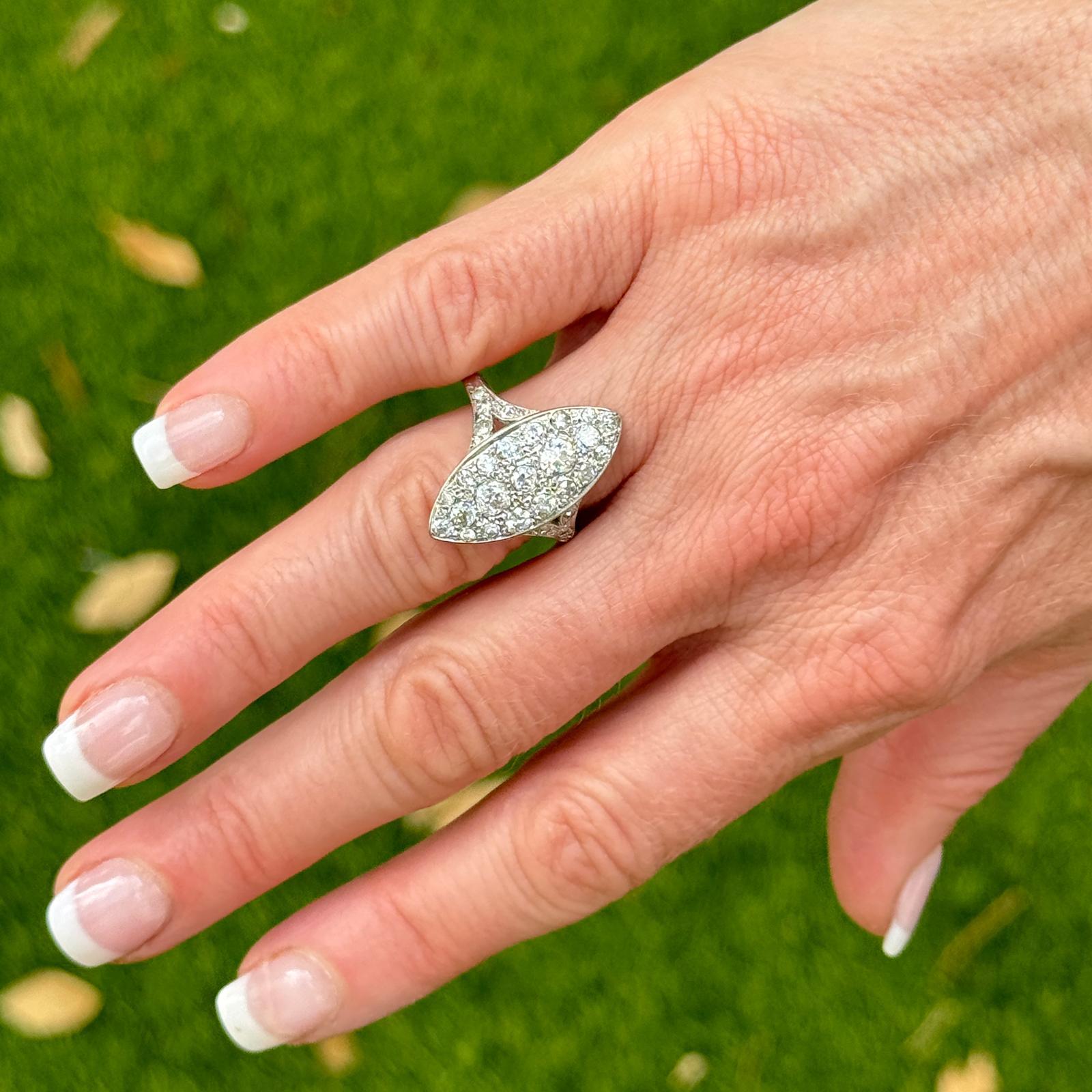 The vintage diamond navette cocktail ring is a stunning example of vintage elegance, showcasing exquisite craftsmanship and timeless design. Crafted in 14 karat white gold, the ring is adorned with 29 old european cut diamonds weighing approximately