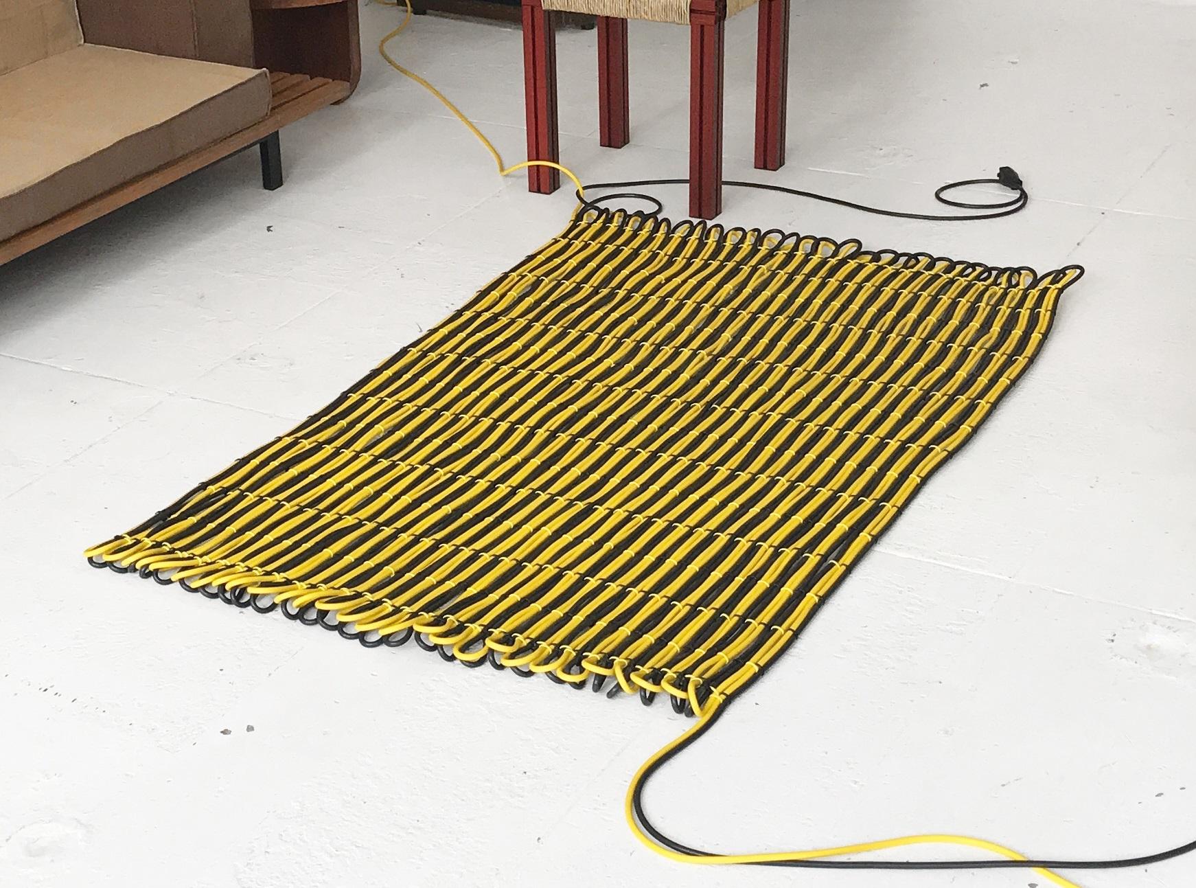 200 Meter cable rug by Tino Seubert.
Dimensions: W 105 x L 160 cm (˜ 1.7 m2 surface).
Materials: PVC electricity cable, cable clips, country specific plug and socket.
Cable colours: black, yellow, orange, blue (two can be mixed). 

Tino Seubert
When