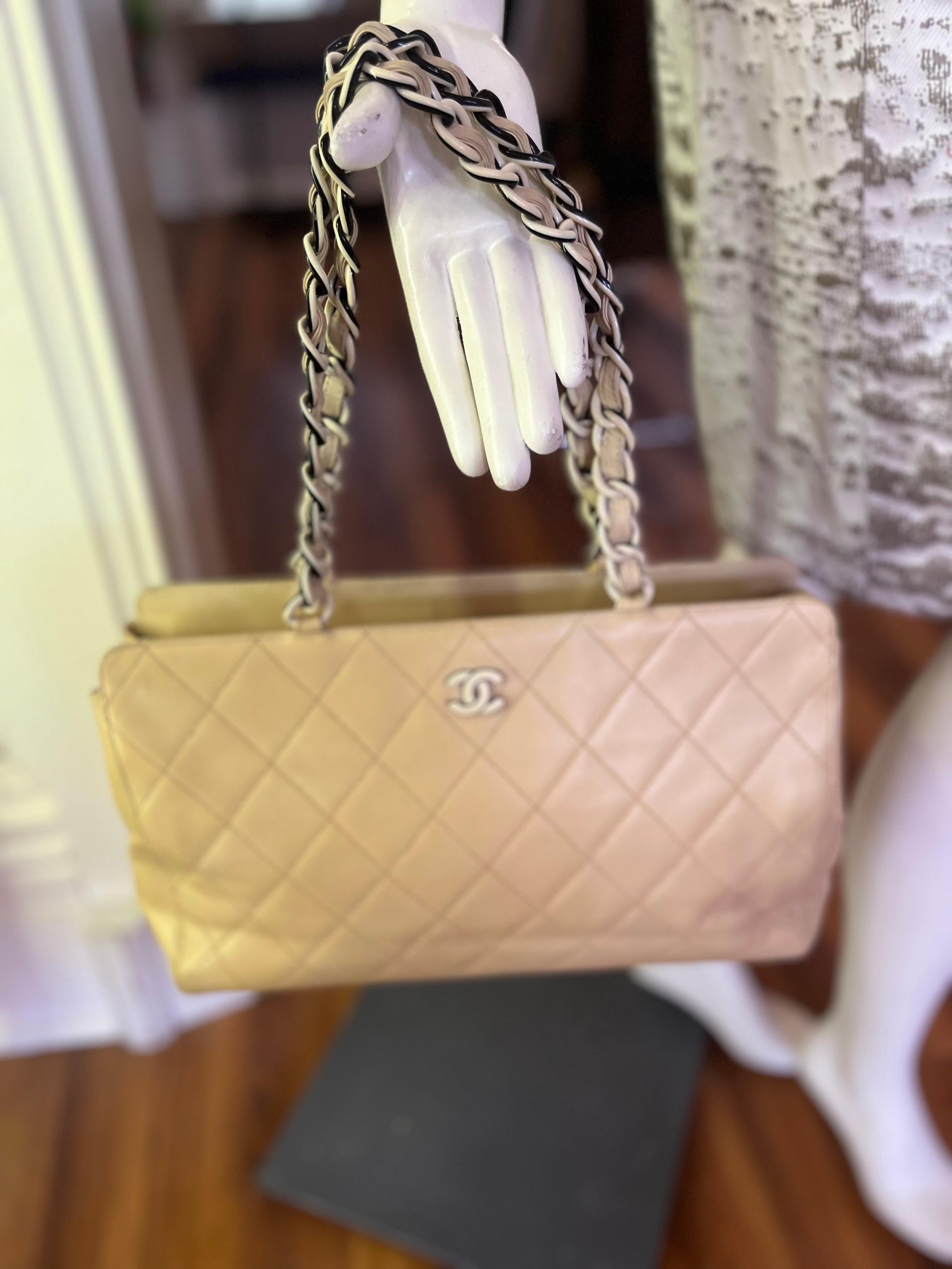  A very light beige (with a hint of yellow) quilted lambskin tote bag with a nice two colored interlocking chain; a ceramic CC at the front; a top zip; leather lining; two inside pocket, one with a zip, and serial#6497588 inside the zip pocket.
It