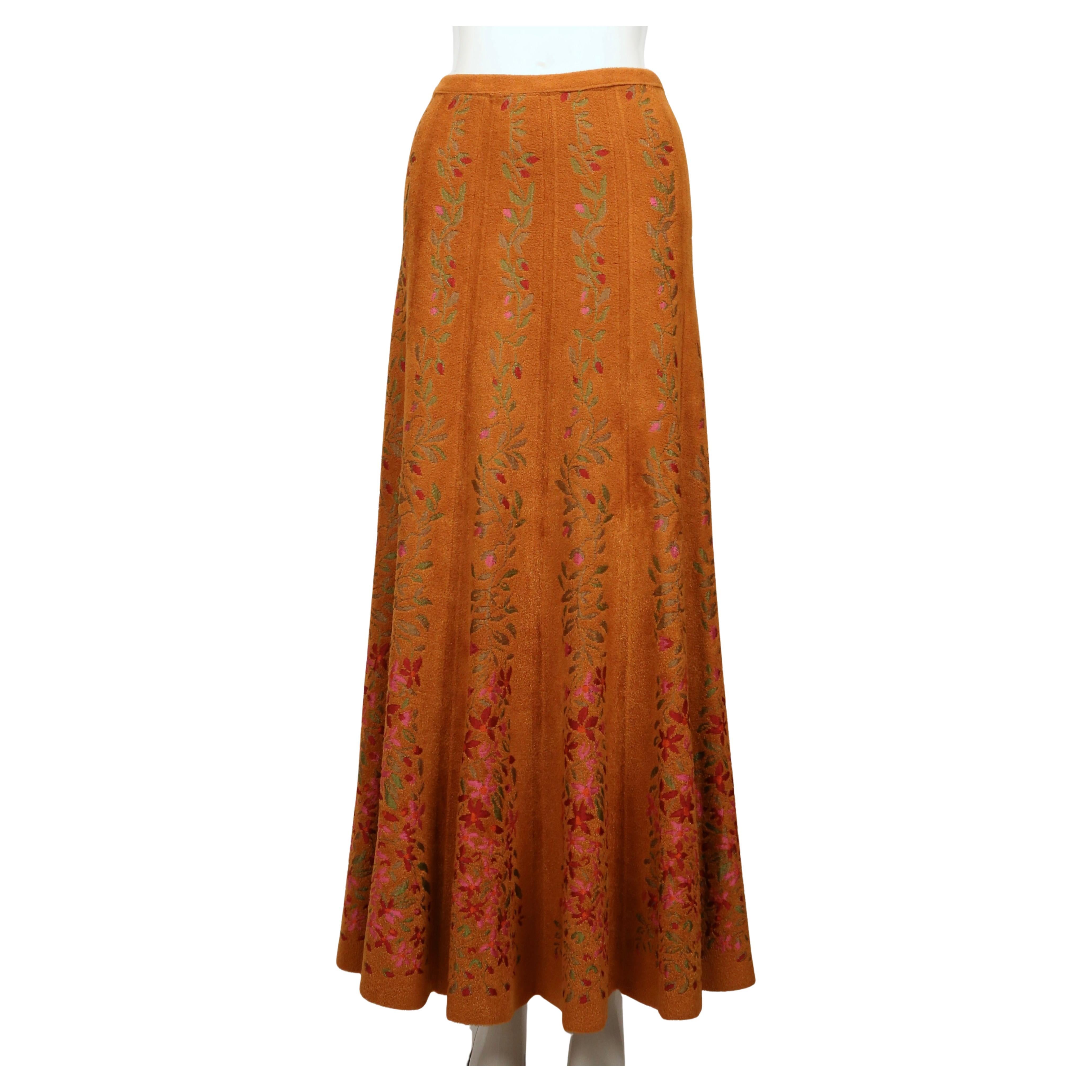 La espectacular falda Azzedine Alaïa de otoño de 2000 es un ejemplo sorprendente del excepcional uso que hace el diseñador de la textura y la silueta. Diseñado con una base de chenilla naranja, presenta motivos de enredaderas verticales ricamente