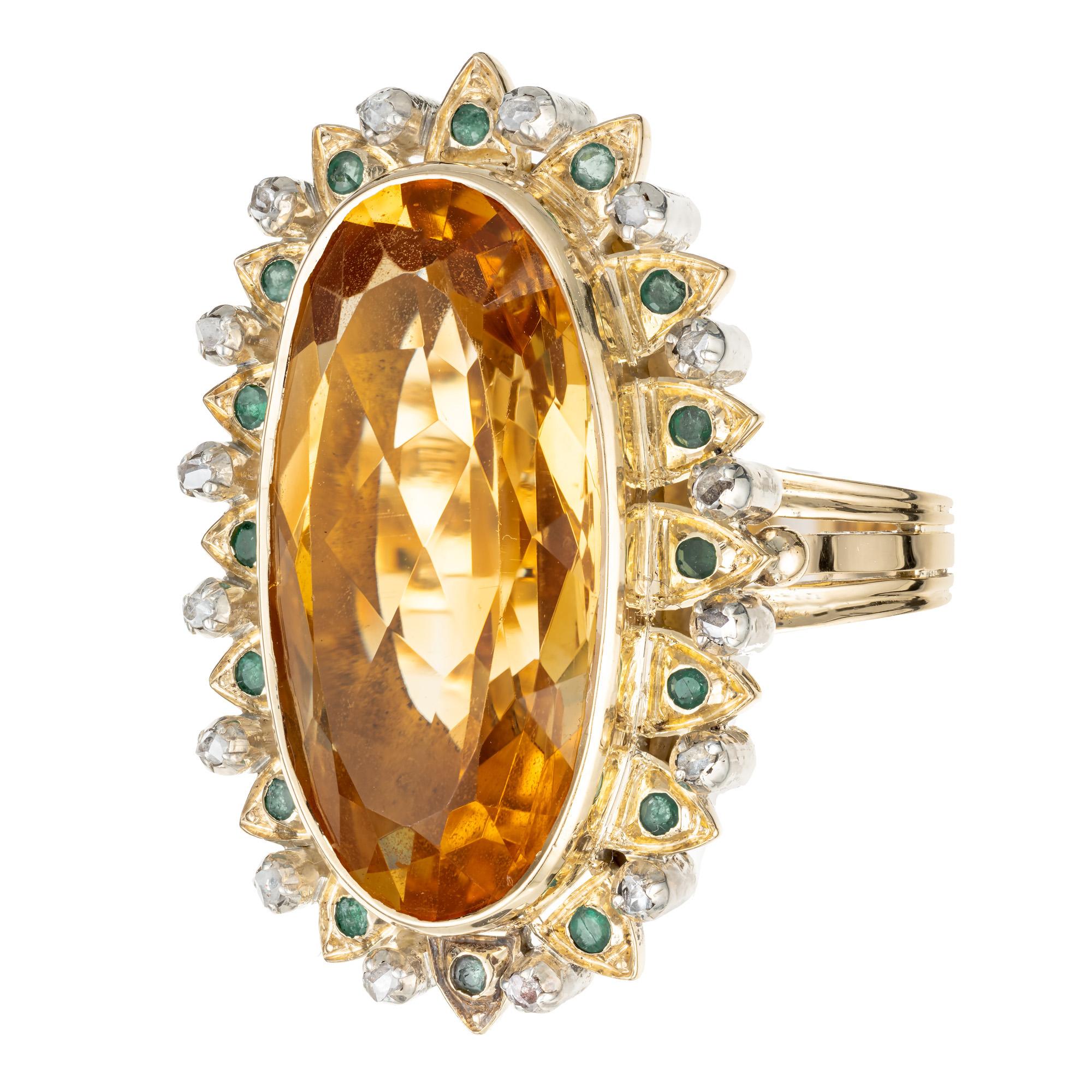 Citrine, emerald and diamond handmade cocktail ring. Oval yellow 20.00ct center citrine. Set in 18k yellow gold with a halo of round cut emeralds and diamonds. Circa 1910 to 1920.

1 genuine yellow Citrine, approx. total weight 20.00cts, VS, 25 x