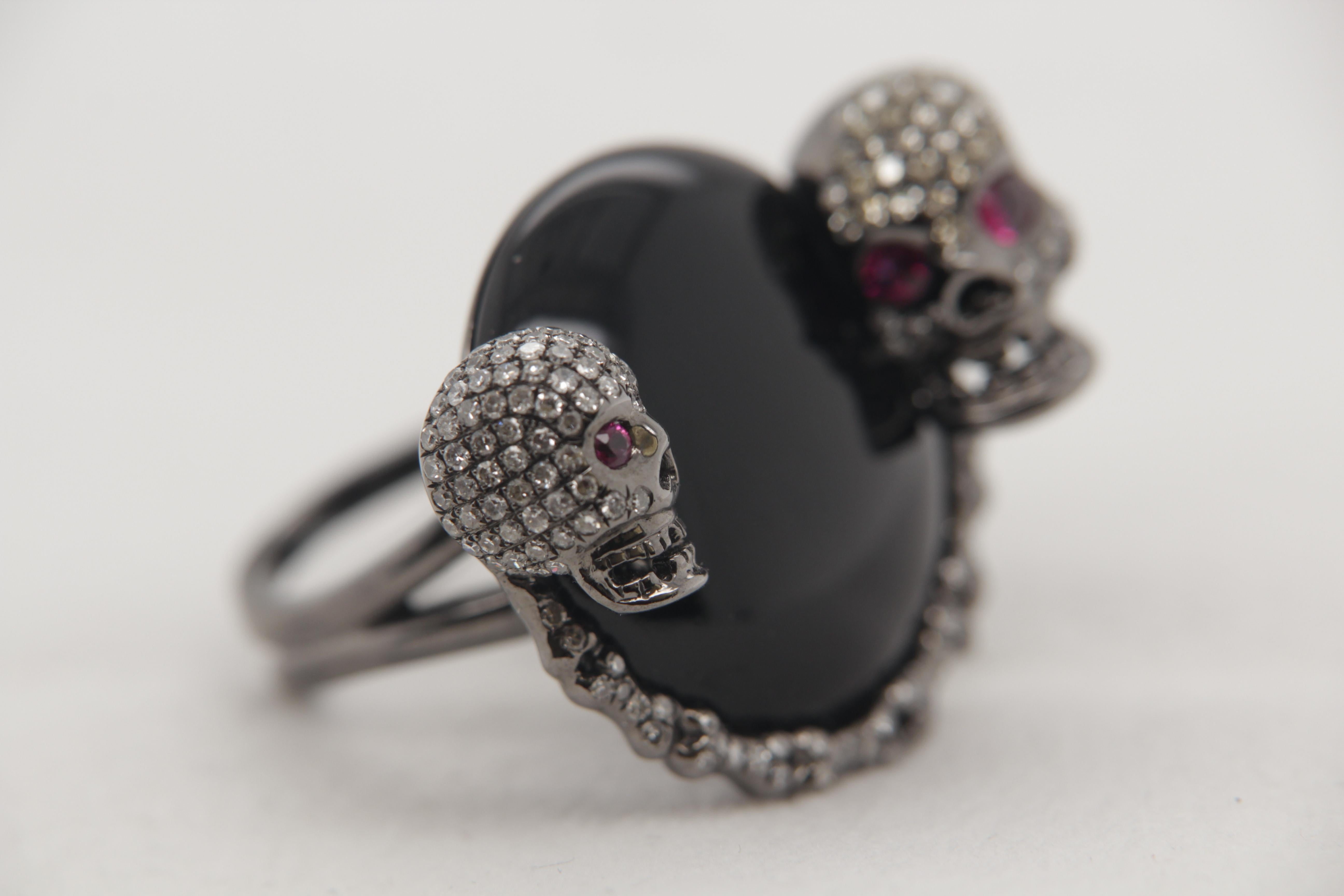 A brand new onyx and diamond ring in 18 karat gold. The onyx weigh 20.00 carat, ruby weigh 0.42 carat and diamond weigh 2.17 carat. The total ring weight is 20.48 grams. The ring resembles two skull.