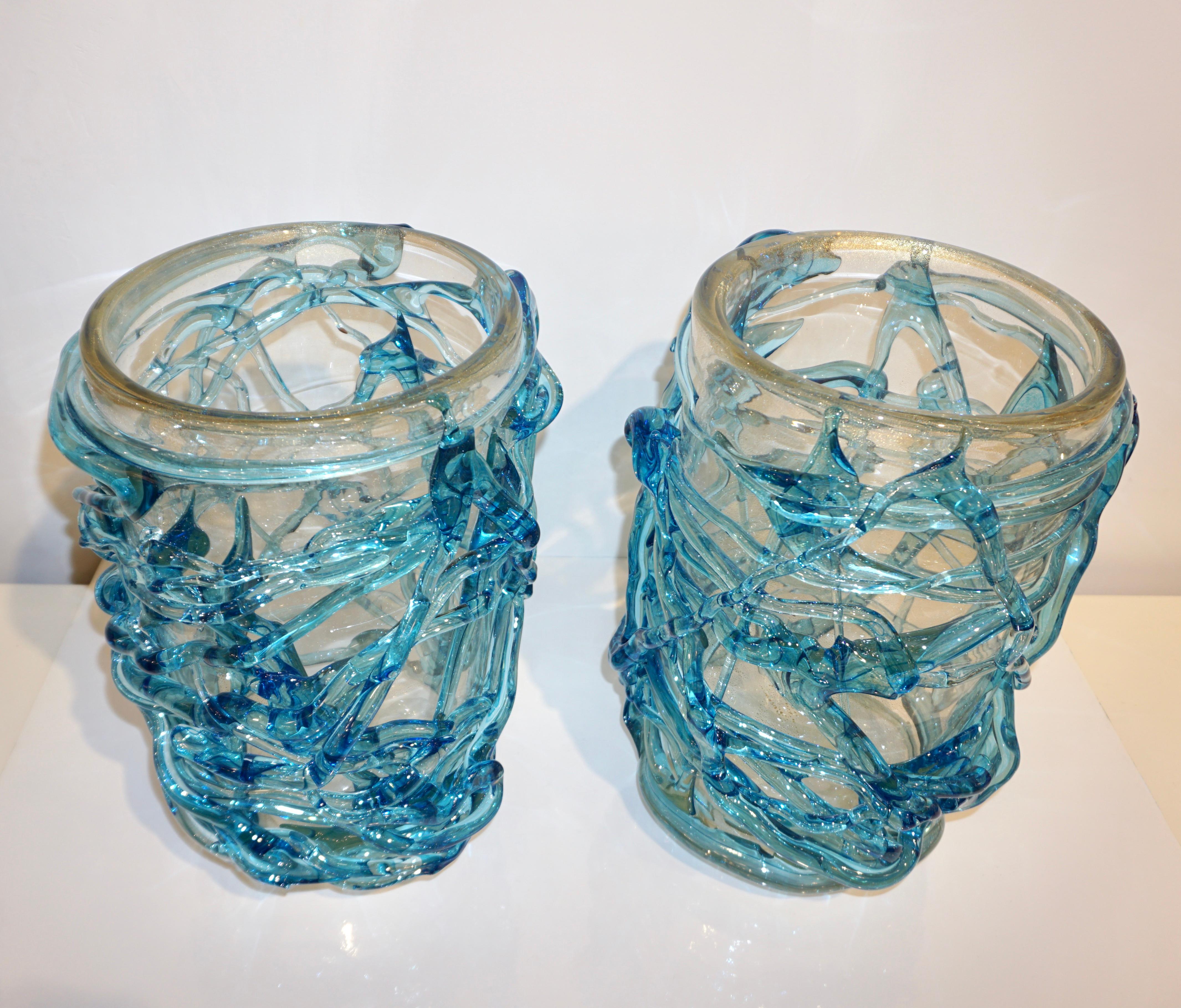 Étonnante paire de vases sculpturaux vénitiens en verre de Murano de haute qualité du début du 21e siècle, le corps en verre soufflé transparent et cristallin est largement travaillé avec une inclusion de poussière en or 24 carats, décoré d'une