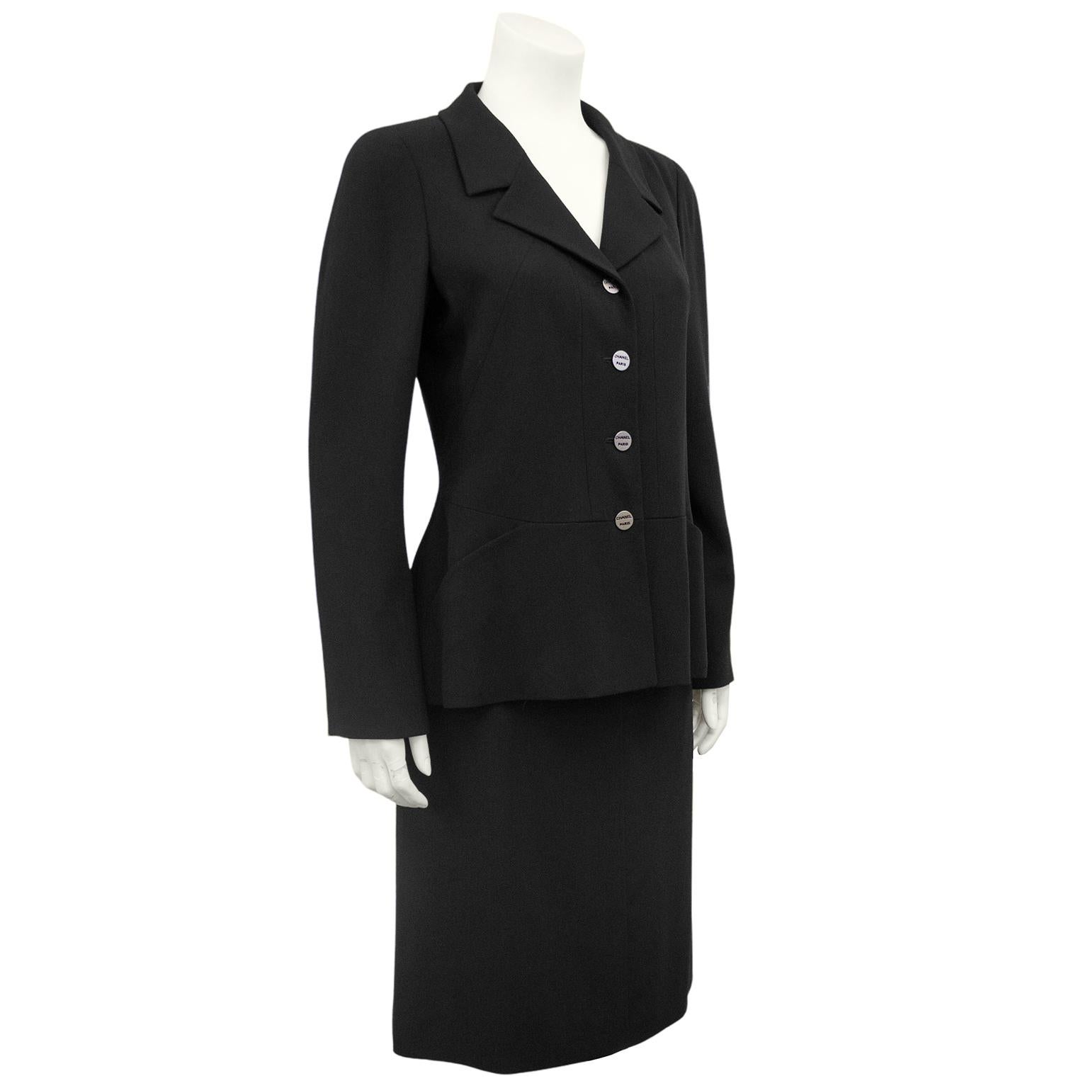 Classic black Chanel skirt suit from the year 2000. Timeless black blazer with silver 'Chanel Paris' buttons. Blazer is beautifully constructed - fitted through the body with a vertical seaming. Horizontal seam at waist creating flattering and