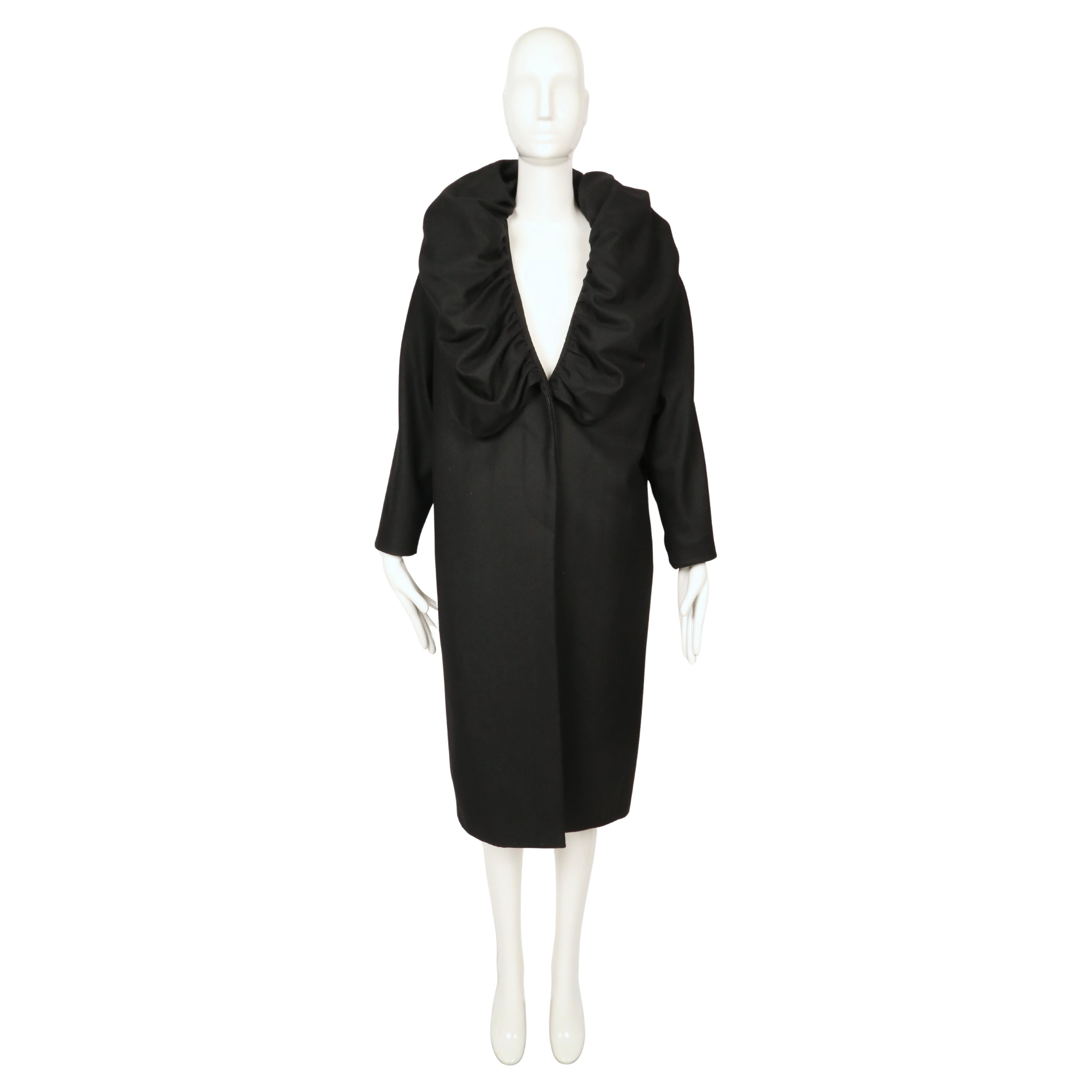 Raro cappotto nero di Dries van Noten della collezione autunno 2000. Realizzato in una lussuosa miscela di lana, seta e cachemire, il cappotto ha una mano morbida ma strutturata, che offre sia calore che drappeggio. La silhouette di media lunghezza