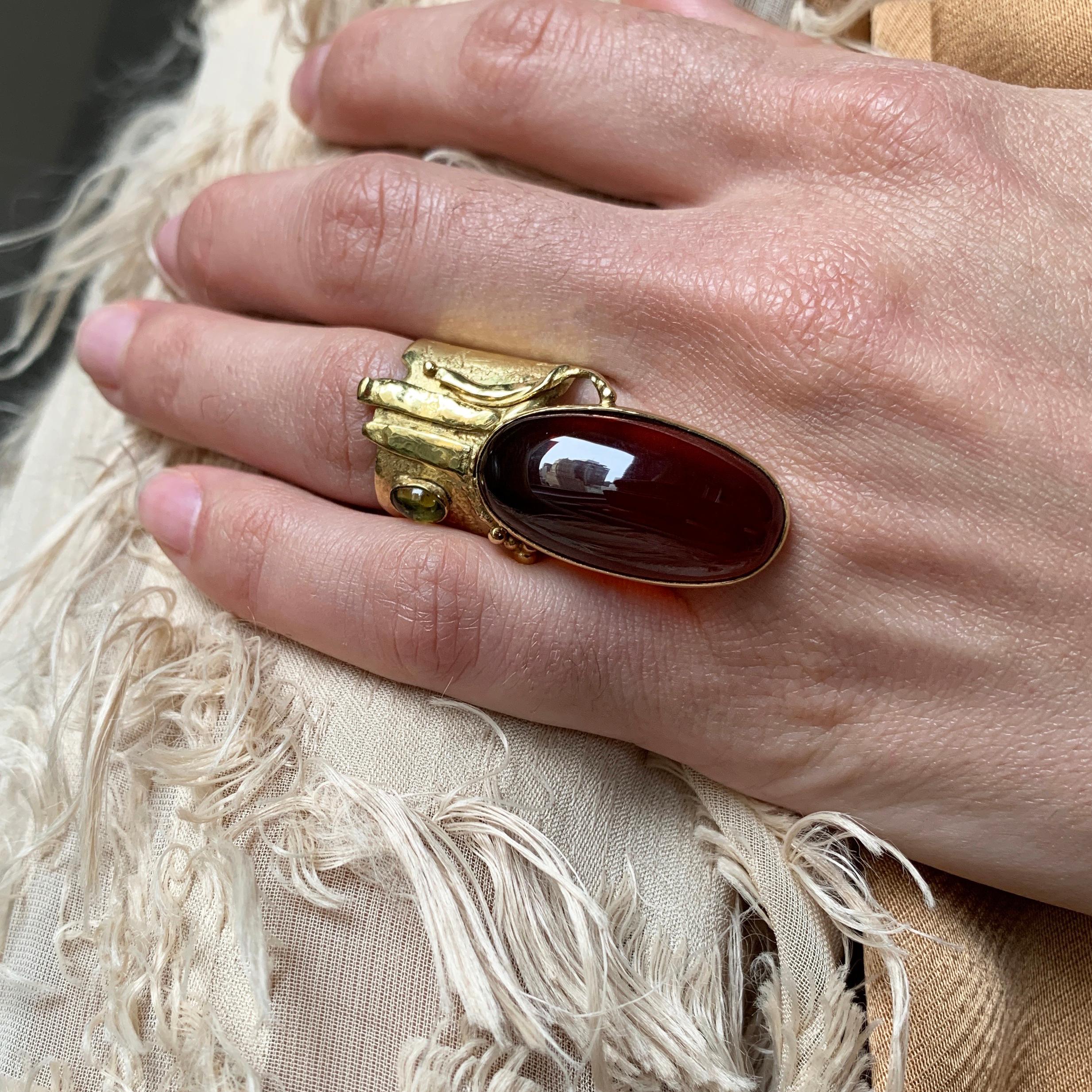 A large oval garnet, peridot and 18 karat gold ring by British jeweler, Florence Kirk, 2000. This ring is a size 7.25 and it measures 1.7