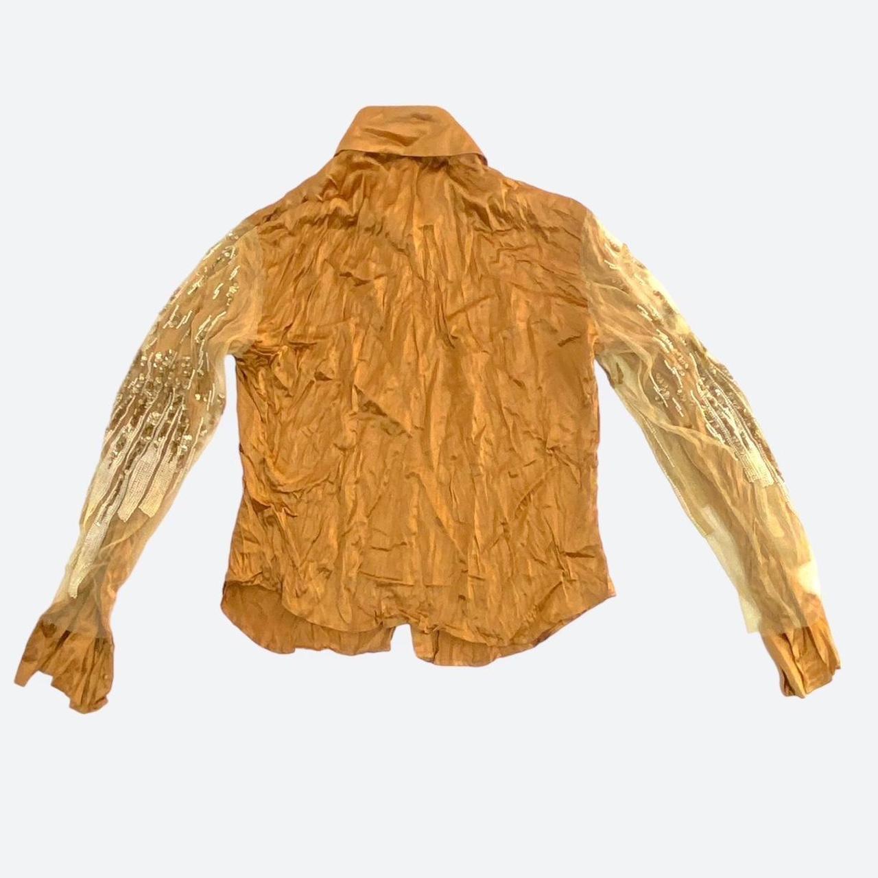 100% silk shirt from the early 2000s in a rich caramel tone of gold with a gorgeous satin glow due to the high-quality silk fabric, which is enhanced by a textured, creased finish. The sleeves are covered with a tulle layer that is completely