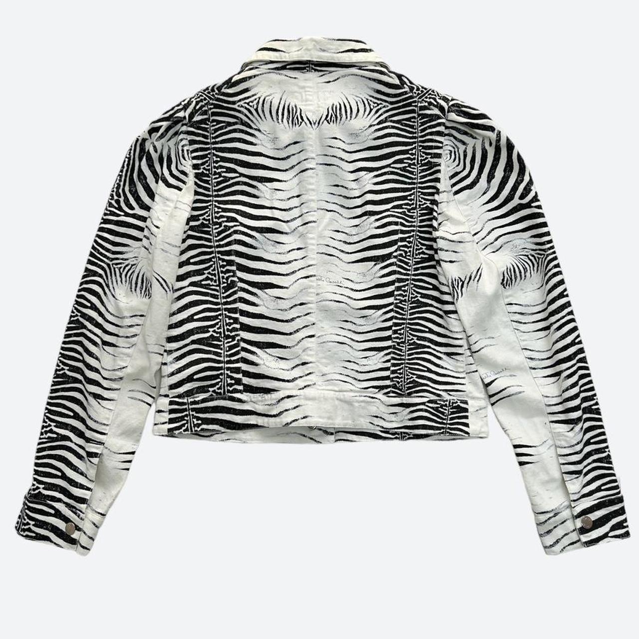This jacket from the Roberto Cavalli SS 2000 collection offers a unique take on the
classic biker style and silhouette, one that displays a carefully placed symmetrical
zebra print all over.
Waist-length and in a size L, this cotton jacket features