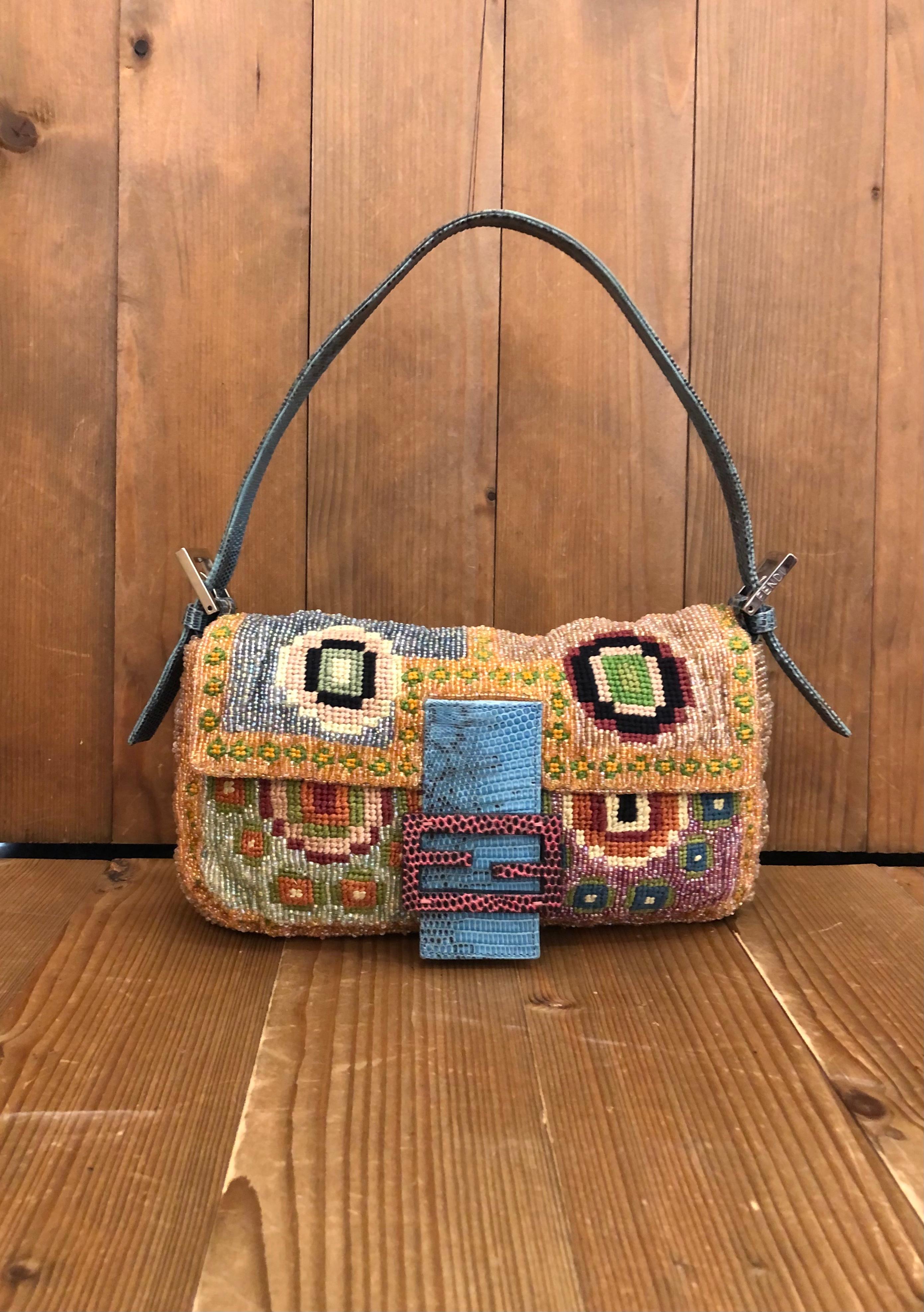 This iconic Fendi Baguette hand bag is exquisitely crafted of embroidery and beads in various colors and trimmed with exotic leather in turquoise. Front flap magnetic snap closure open to a silk satin interior in fluorescent green featuring one