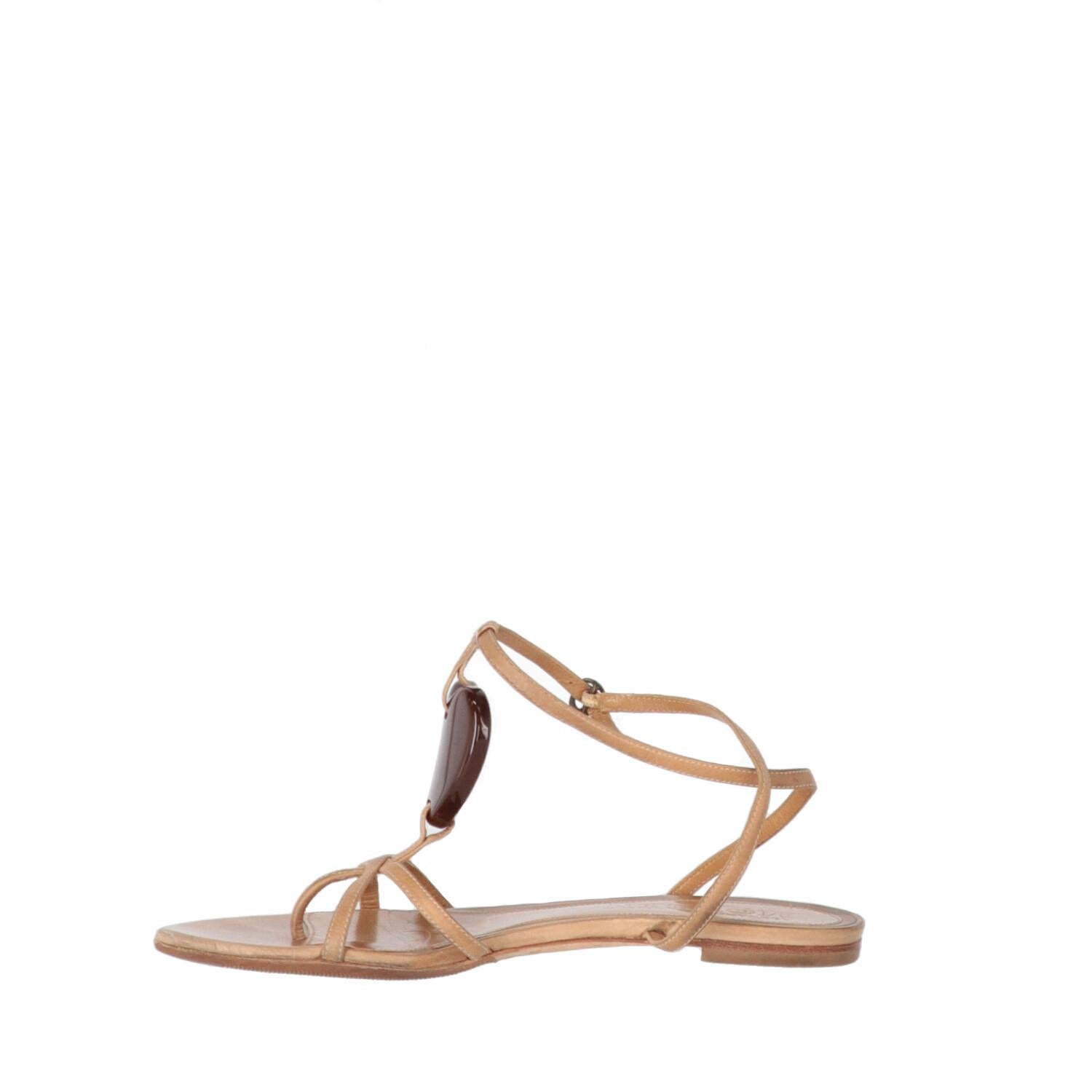 Alexander McQueen flat sandals in beige leather. Thong model, ankle closure with strap and heart-shaped insert on the instep. Leather insole with logo and flat sole.

The item shows slight sign of wear on the leather and scratches on the heart, as