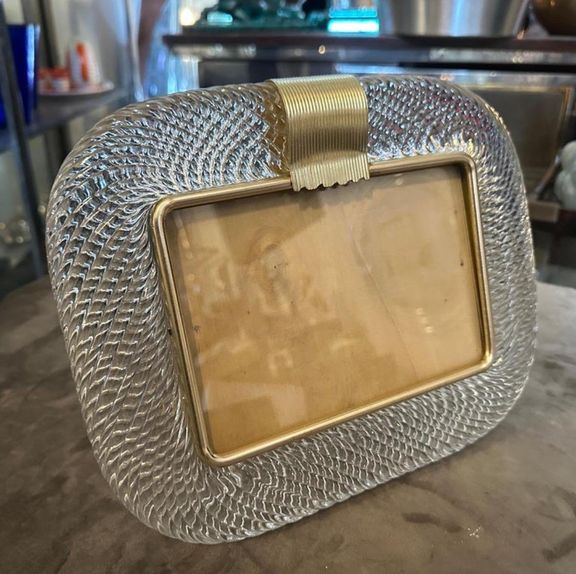 A clear murano glass picture frame designed and manufactured in Venice in the style of Barovier, the frame it's in lovely conditions. This vintage photo frame is a beautiful and elegant piece of decor that is perfect for displaying your favorite