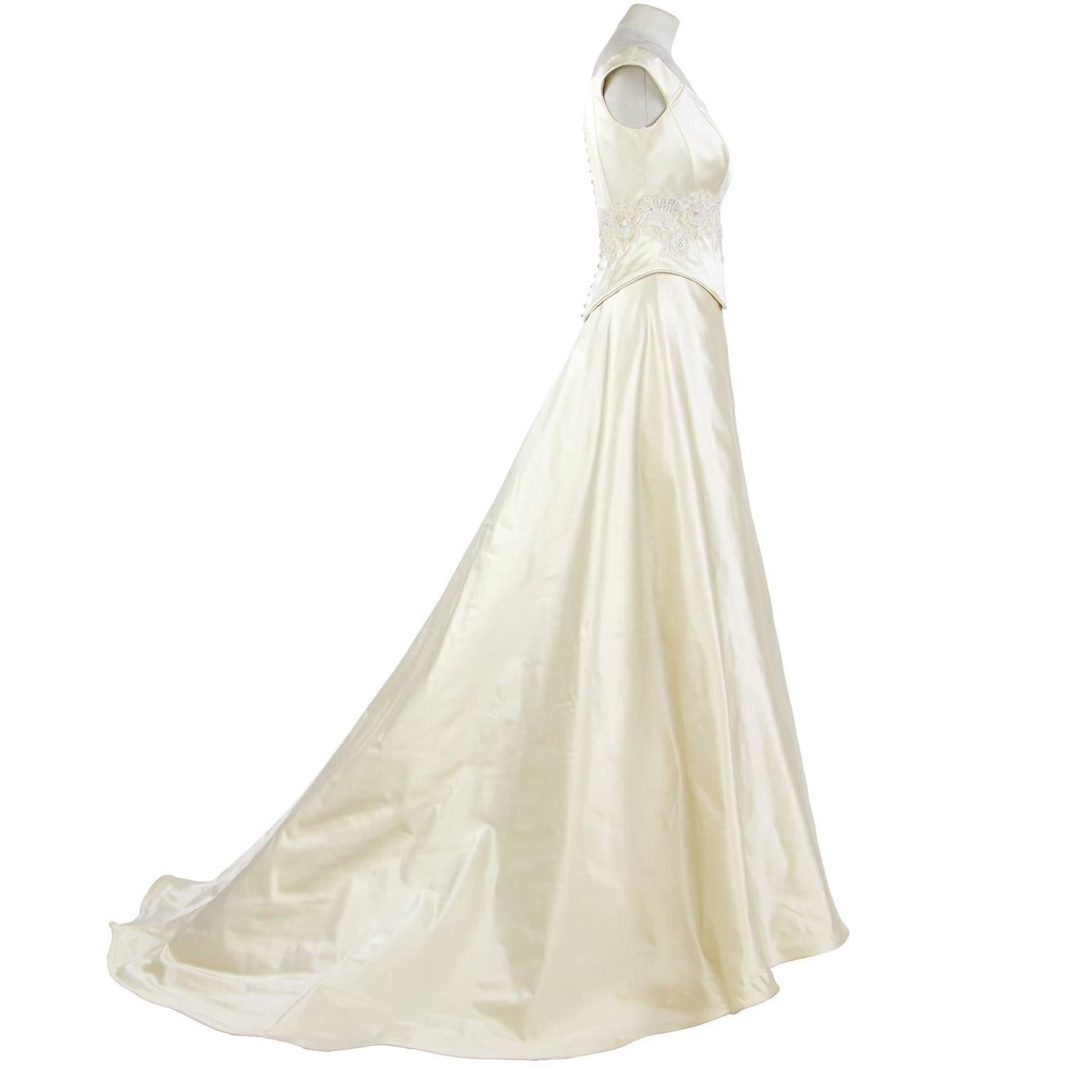 Marvelous princess dress by Atelier Aimée in ivory withe silk, from the 2000s. It features two pieces, one off-the-shoulders neckline top with slats, decorated with lace, beads and sequins, and a wide skirt with layers of tulle veil, a petticoat and