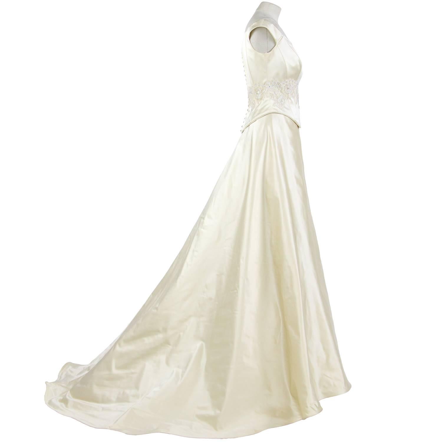 Meraviglioso abito da principessa di Atelier Aimée in seta avorio, degli anni 2000. È composto da due pezzi, un top con scollatura e stecche, decorato con pizzo, perline e paillettes, e un'ampia gonna con strati di velo di tulle, sottogonna e
