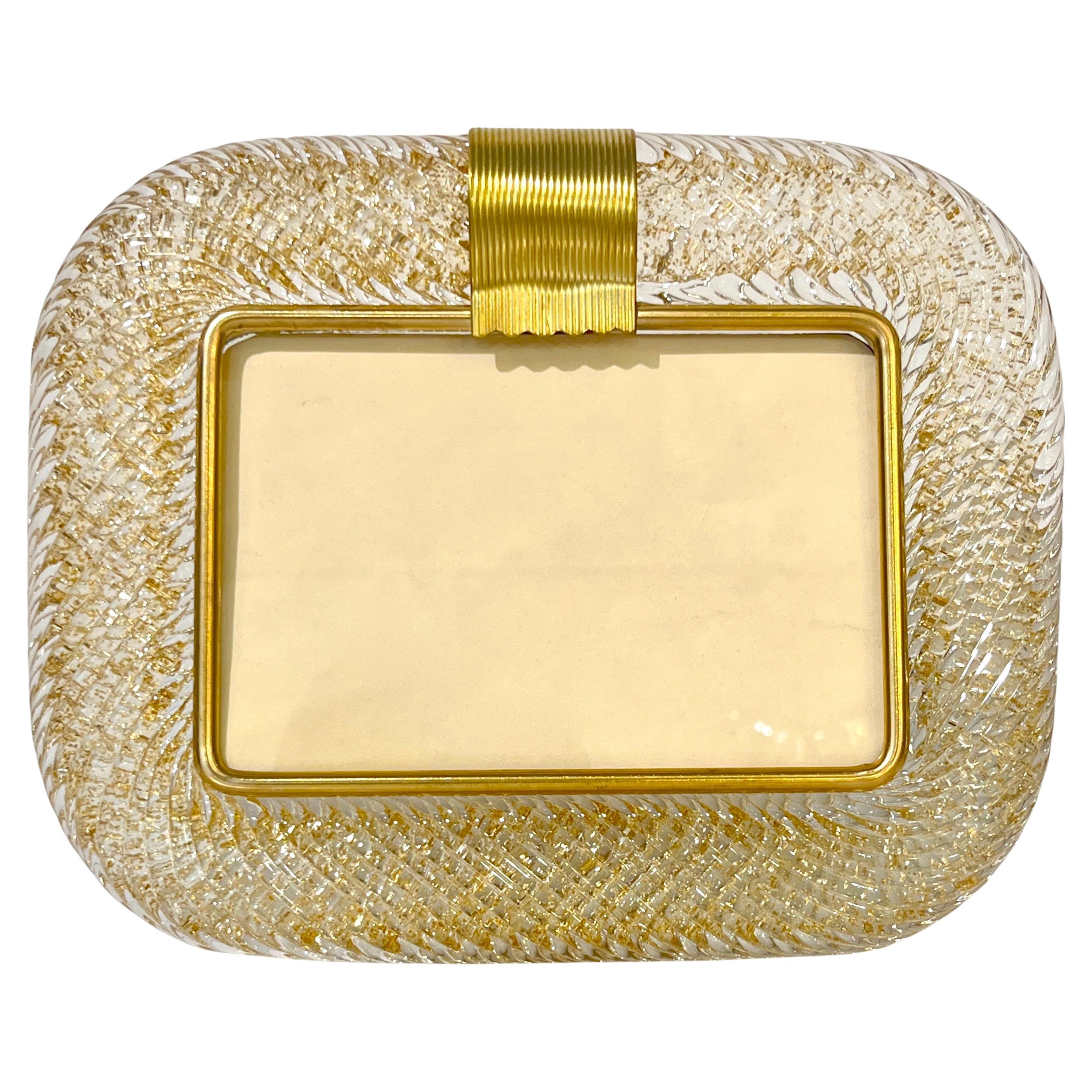 A sophisticated Venetian modern design horizontal photo frame in thick blown Murano glass worked with luscious gold leaf within the crystal frame, by Barovier Toso, signed piece. The elegant texture of the tightly twisted glass frame in the Torchon