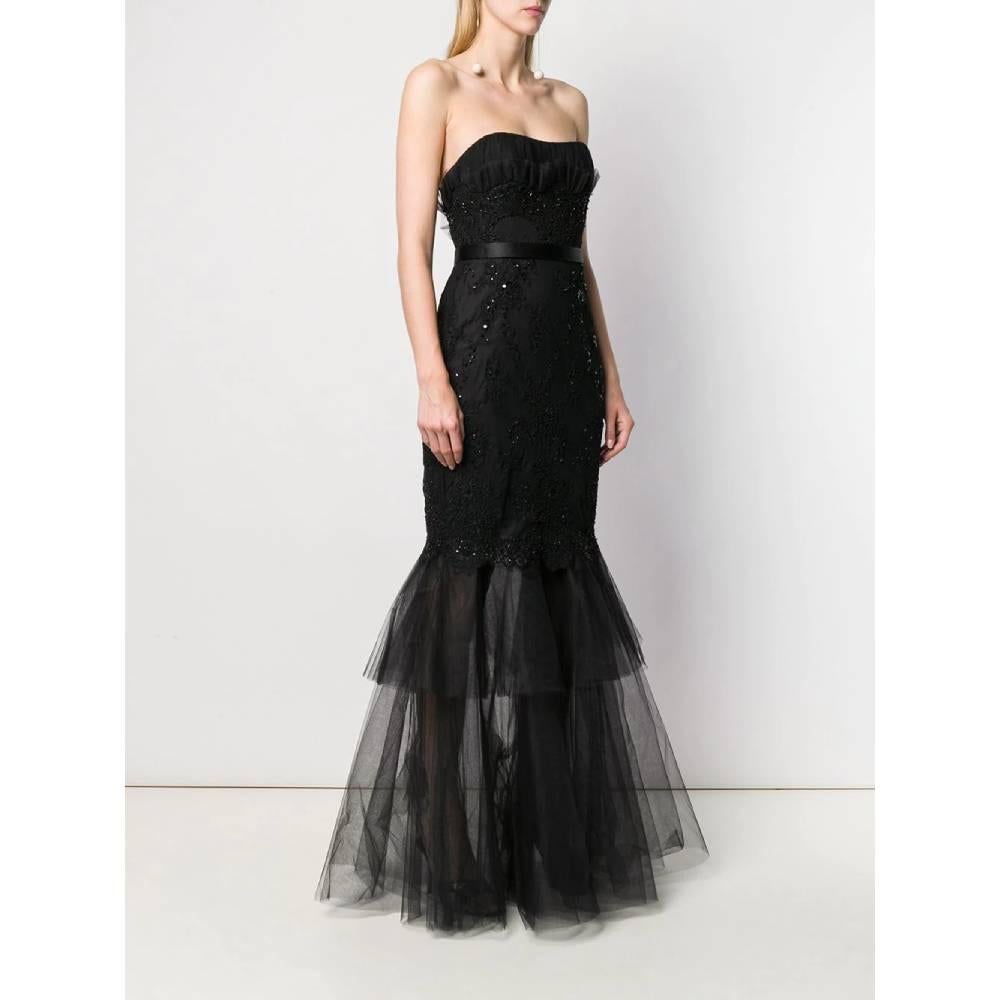 Black evening dress in lace and embroidery adorned with beads and sequins. Mermaid model with sweetheart neckline with decorative tulle on the bodice and on the bottom. Back zip and hook closure.

The product has a mending on the final part of the