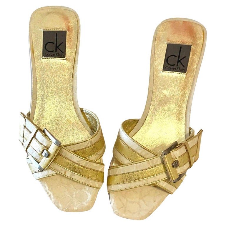 Sandalias planas de doble tira cruzada doradas Calvin Klein de los