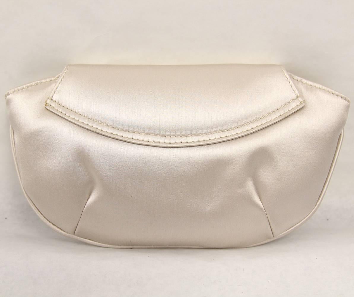 Incredibly elegant and chic Calvin Klein clutch in ivory silk from the 2000s. This piece is perfect for the evening and features a clasp lock with rhinestones. The interiors include a  pocket. Excellent conditions.

Measurements:
23 cm x 13 cm
