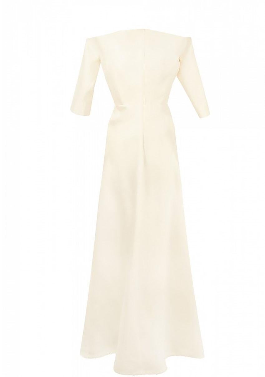 CARVEN 

Carven maxi gown is made of iridescent ivory silk. 
Decorated with a bow on the chest. Lowered shoulder line, cut-off waistline, A-line skirt. 3/4 sleeve, sewn-in corset. 
Back zip closure, matching silk lining.


Content: silk

Size FR