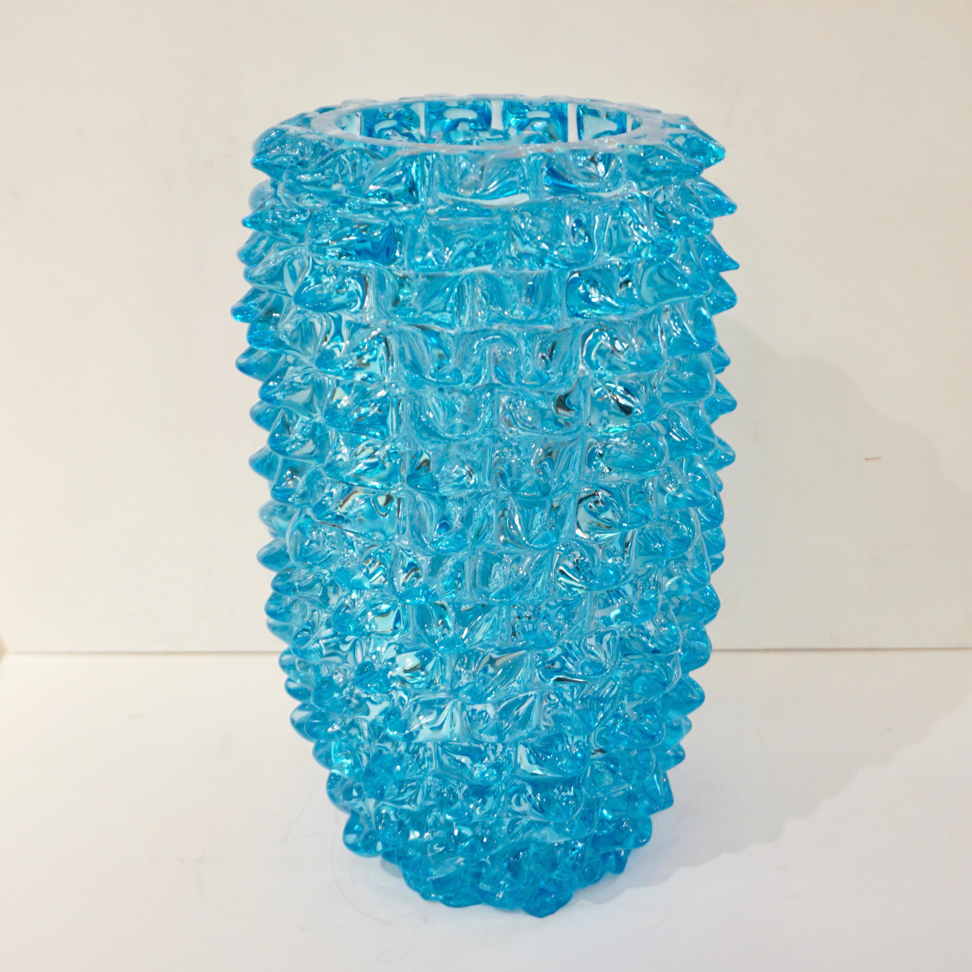 Vaso modernista veneziano contemporaneo firmato Cenedese con un'interessante forma organica allungata e moderna, in un sofisticato colore azzurro turchese, in vetro soffiato di Murano lavorato con la tecnica del rostrato alla Barovier, in cui il