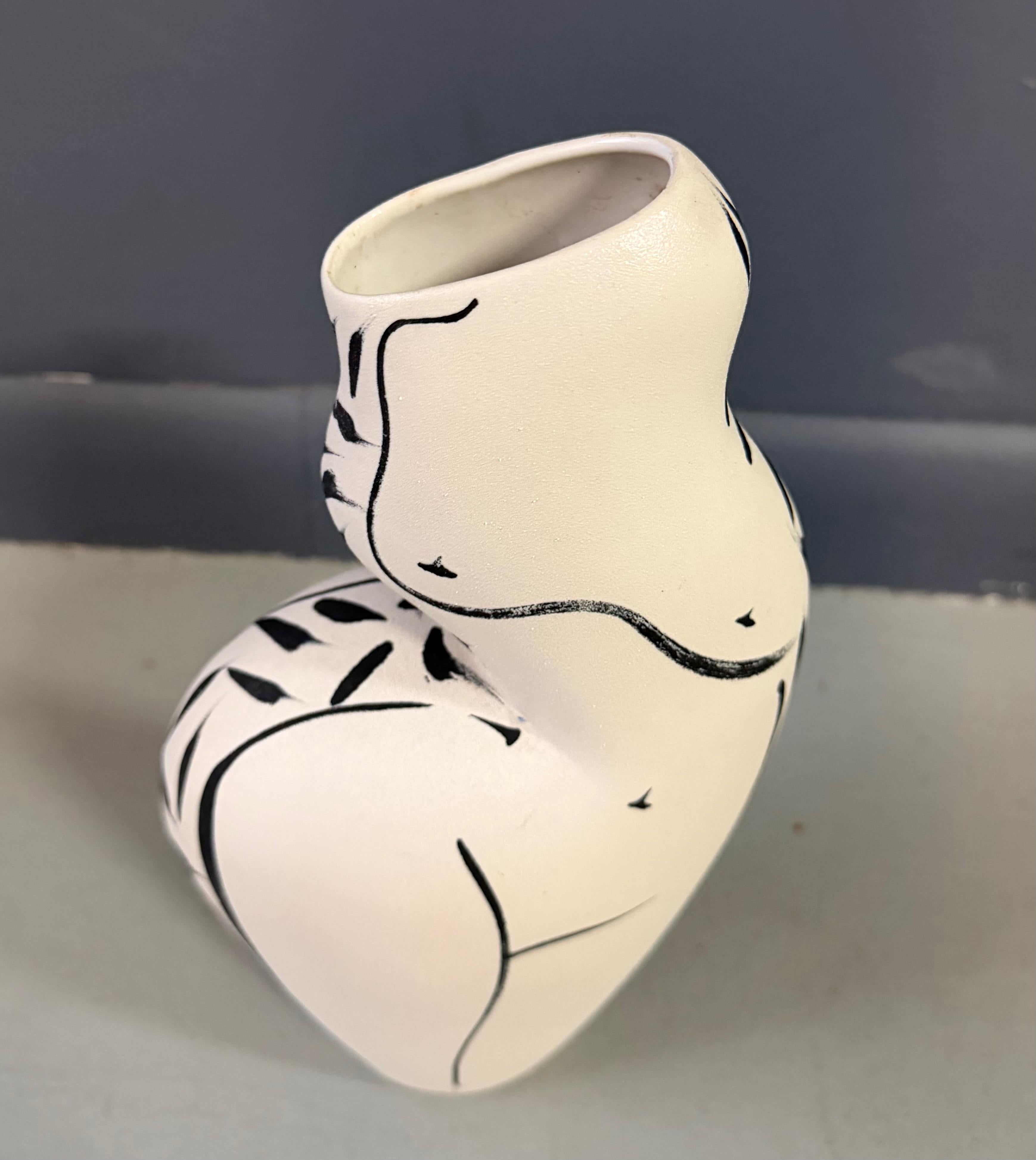 This sculptural ceramic vase by Donna Polseno beautifully captures the grace and sensuality of the human form. Hand-built with Polseno’s signature organic curves, the piece evokes a stylized female torso, its silhouette flowing effortlessly from