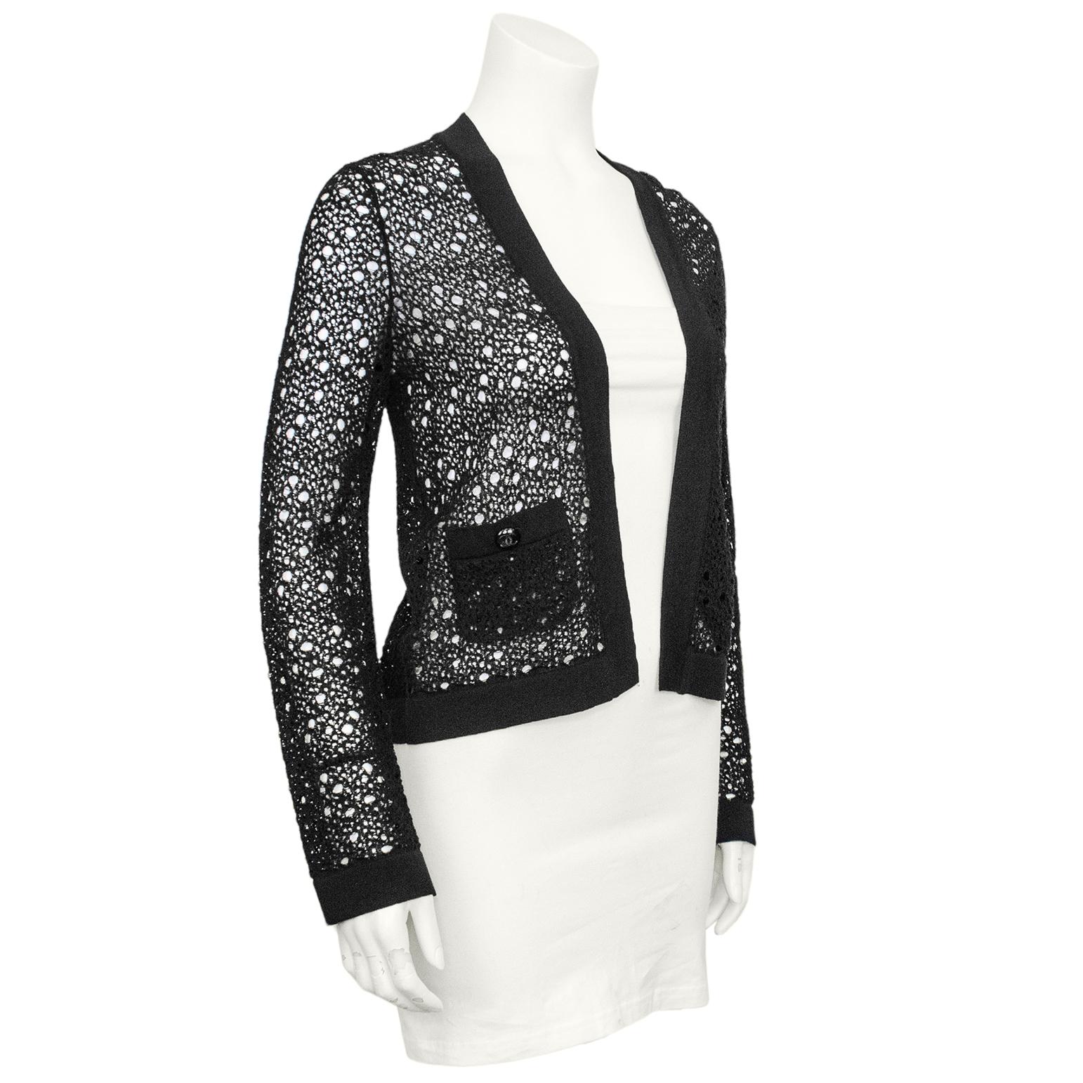 An interesting Chanel cardigan from the mid 2000s. The thin black open weave crochet gives the look of distressed lace. Black ribbed trim and two patch pockets. A great layering piece. Excellent vintage condition. Made in Italy. Marked FR size 34.