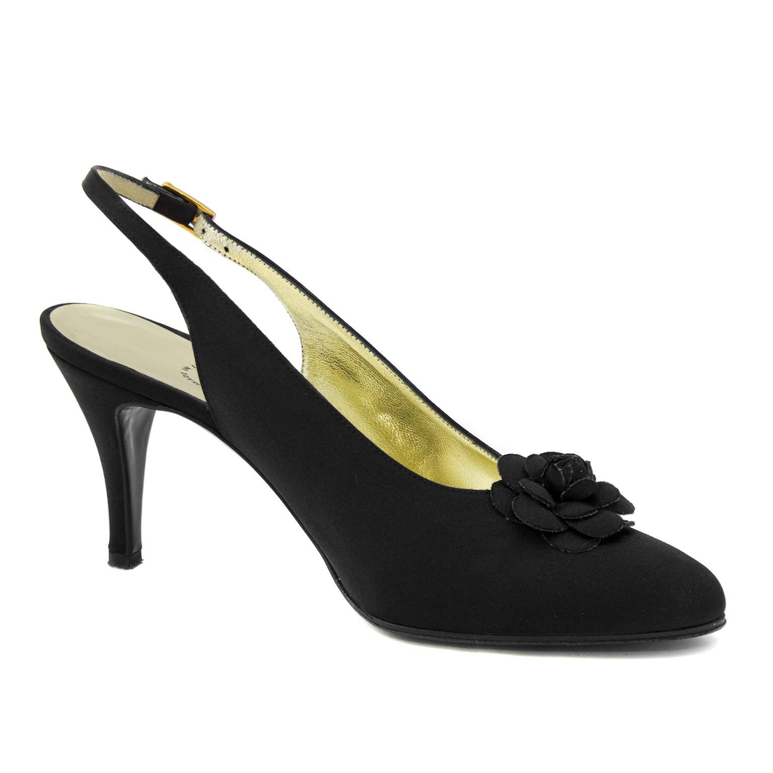Stunning mid height black satin Chanel evening shoes with adjustable sling backs and gardenia rosette on the toe. A slight point to the to box and gold buckle on the heel strap. In excellent very nearly new condition. Fits a US size 6. Marked 6.5.