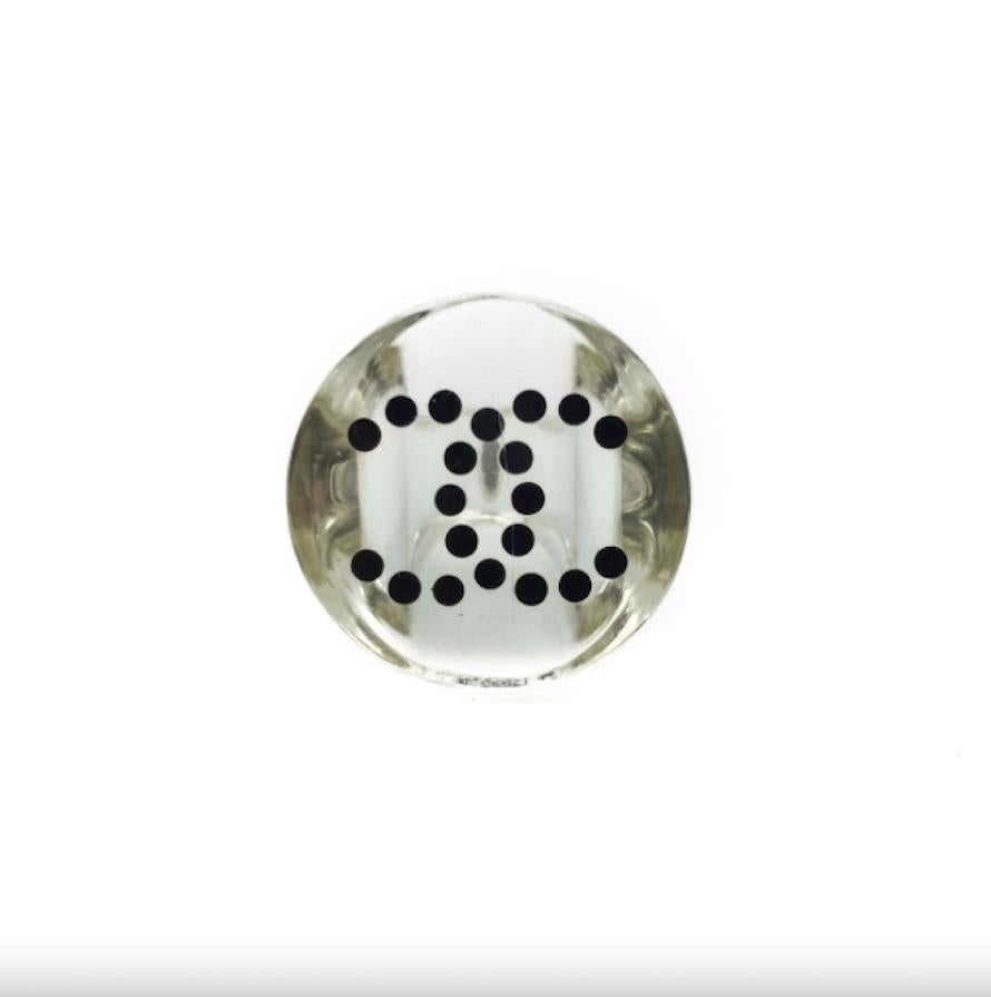 A monochrome resin cocktail ring by Chanel for the 2008 Spring summer collection. The transparent resin is set around the classic interlocking CC initials, synonymous with the House of Chanel. The CC logo is picked out in a black polka dot pattern.