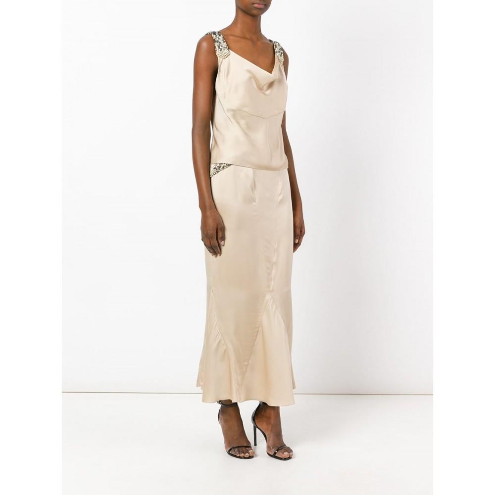 Chanel ivory silk satin suit with gray and white beads ornamental embroidery at shoulders and waist, ankle-length skirt with bias cut and back zip closure skirt, back slit top with pearl branded logo button closure.

The product has some pulled