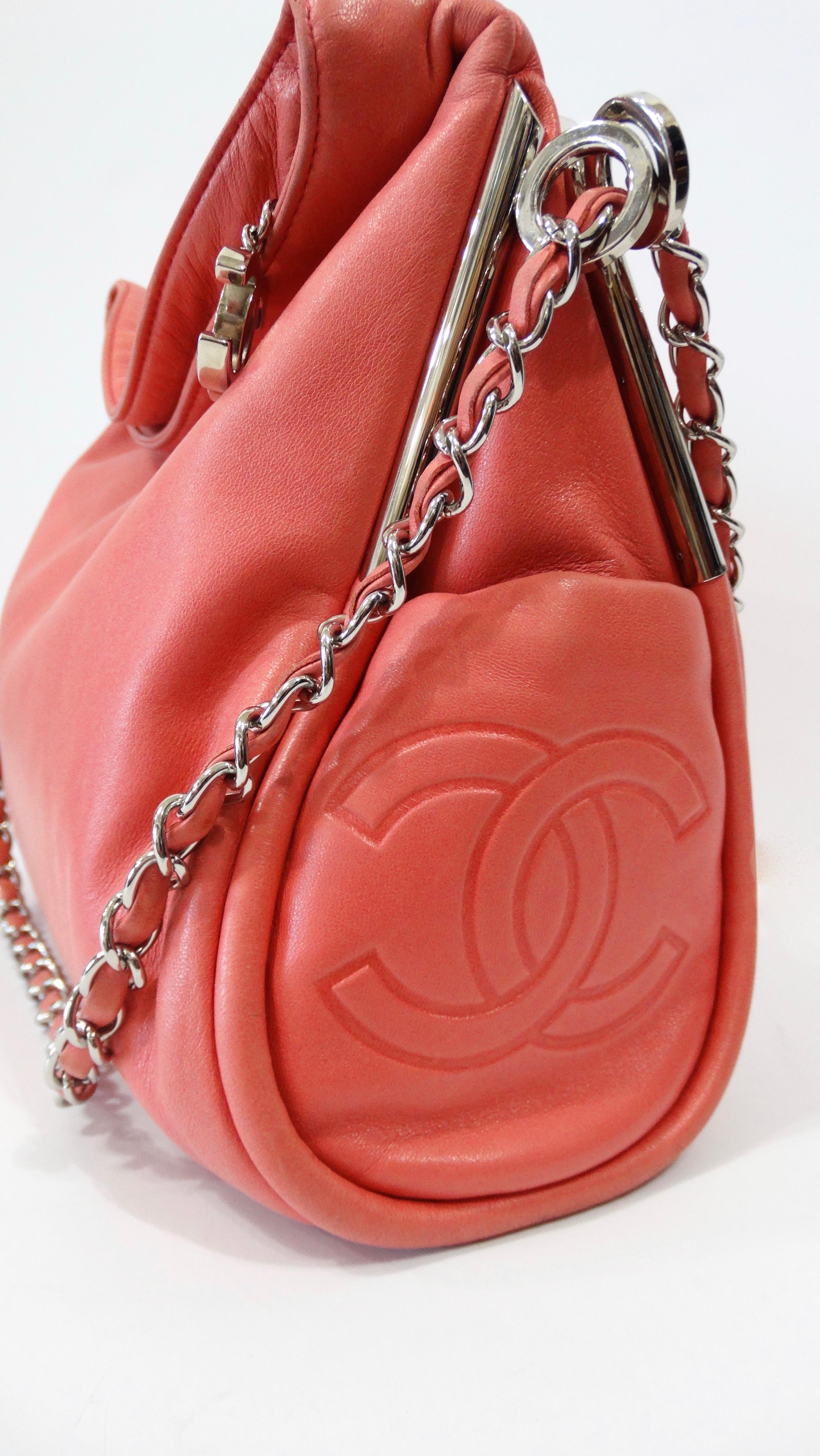 Never have a dull wardrobe moment with this adorable Chanel Ultimate Soft hobo bag! Circa 2004/2005, this hobo bag features soft pink lambskin leather, silver-tone hardware, single chain-link and leather shoulder strap and dual side exterior slit