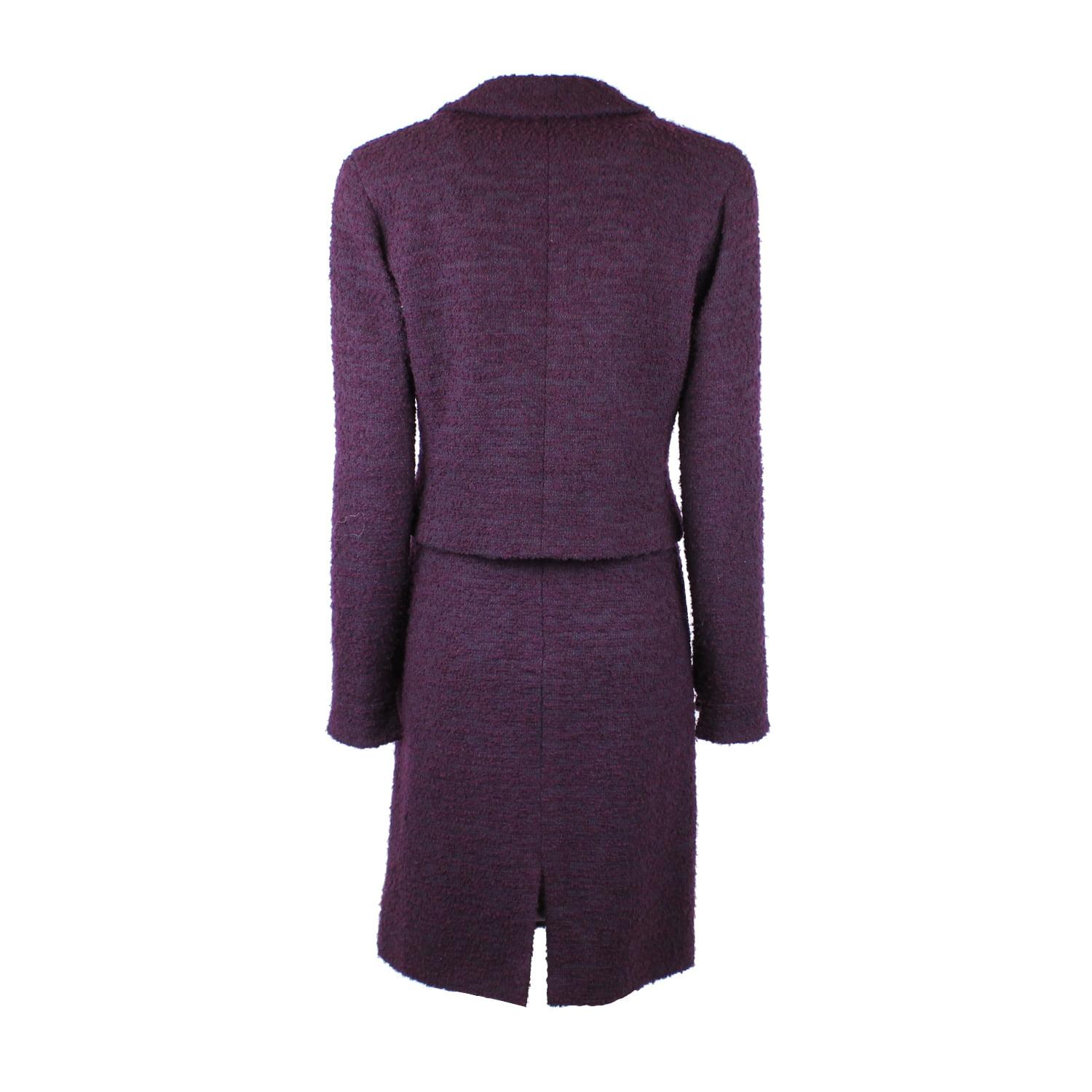 Timeless Chanel boucle wool skirt suit, in a lovely shade of aubergine purple from the pre-fall autumn / winter 2000 collection. The jacket has a classic pointed lapel and an asymmetrical front fastening, complete with three pewter coloured buttons