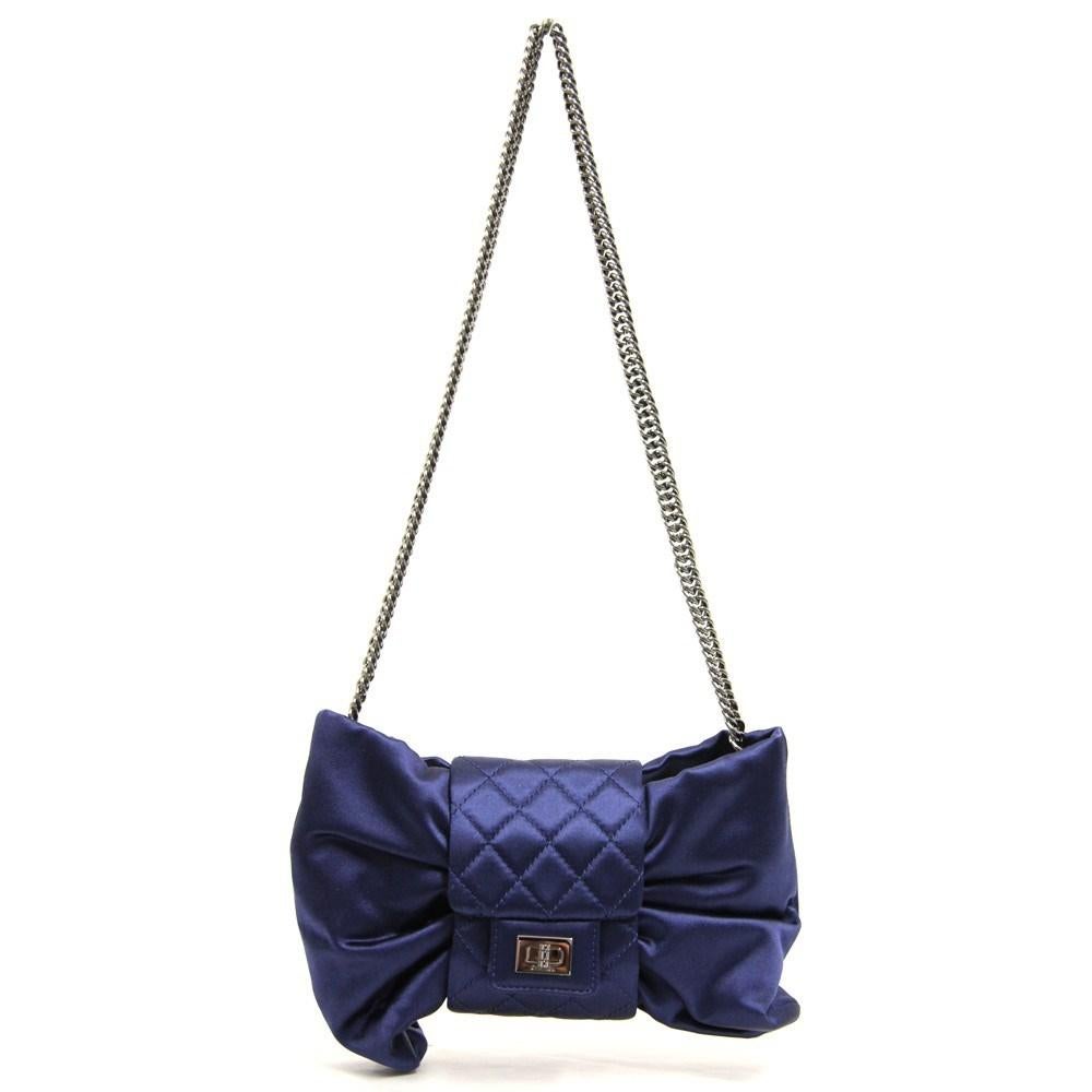 Chanel blue soft silk shoulder bag. Bow design, quilted central detail, small flap with press stud and dark-tone metal Mademoiselle faux lock. Chain shoulder strap. Grey silk lining and inner zipped pocket. Authenticity card.

Measurements

Heigh: