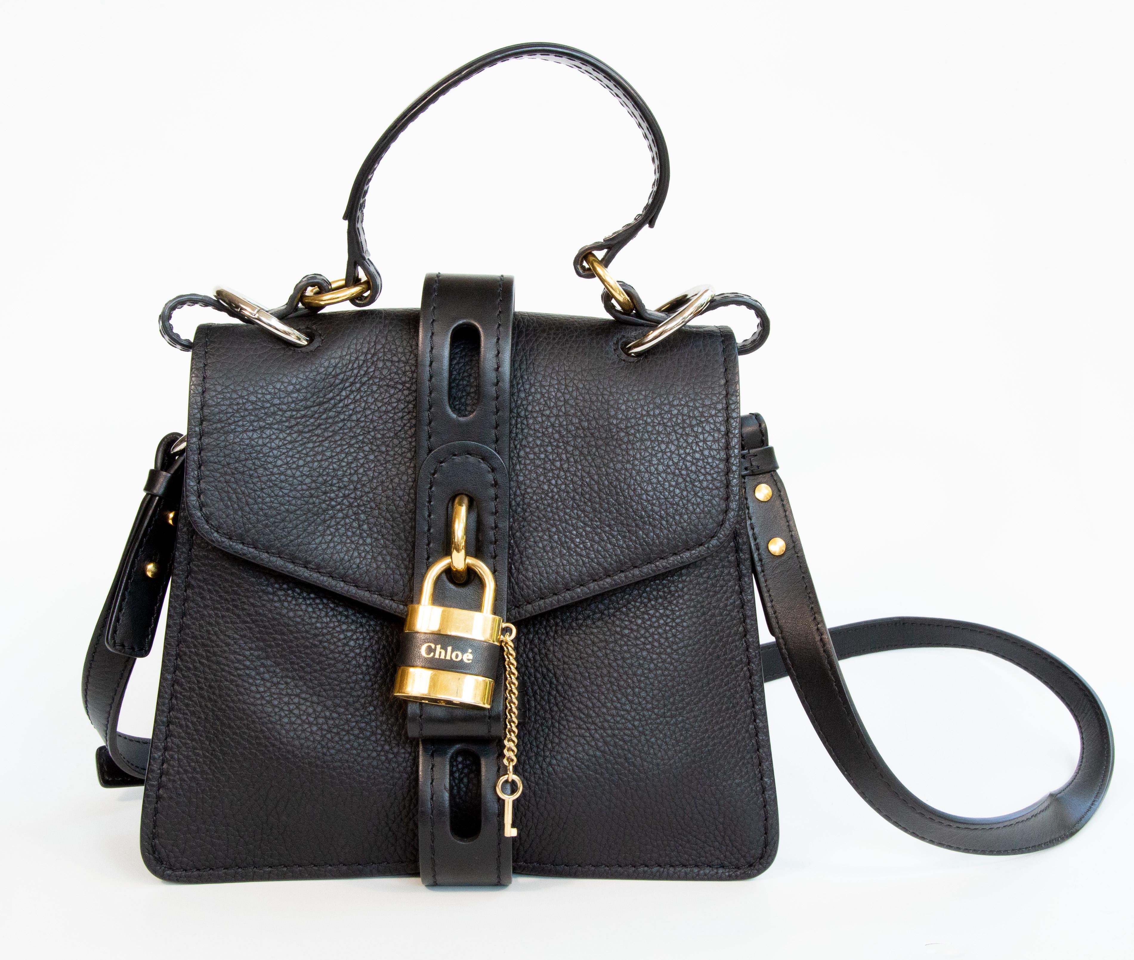 Borsa Chloe Aby in pelle nera con finiture in argento e oro. La borsa può essere indossata come manico superiore o come borsa crossbody grazie alla tracolla (lunghezza massima circa 115 cm). L'interno è foderato in tessuto beige ed è composto da due