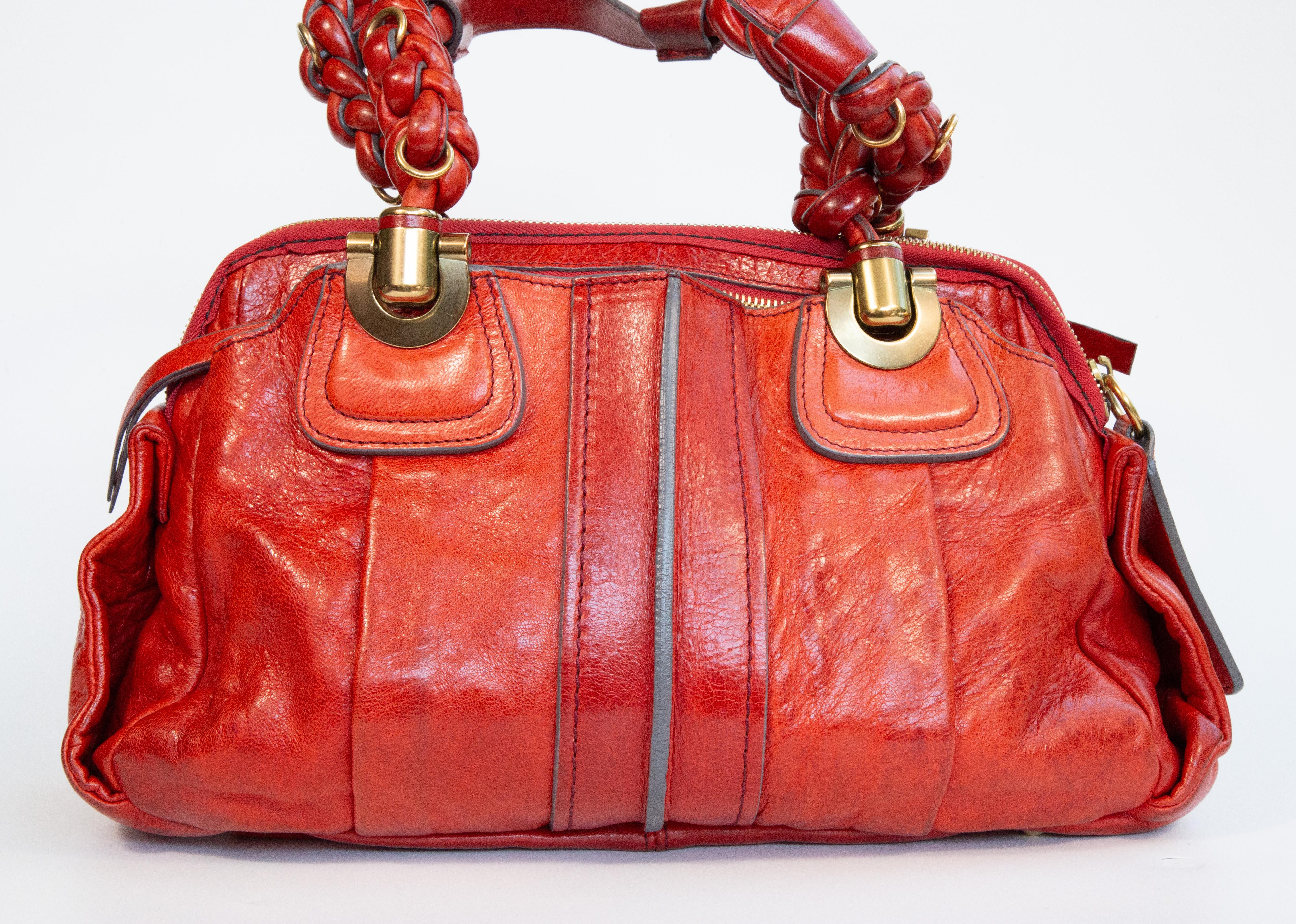 Chloe Heloise Handtasche aus rotem Leder mit goldfarbener Hardware. Die Tasche kann sowohl als Henkeltasche als auch als Umhängetasche getragen werden. Die Griffhöhe beträgt ca. 17 cm und die Grifflänge ca. 40 cm. Der Innenraum ist mit beigem