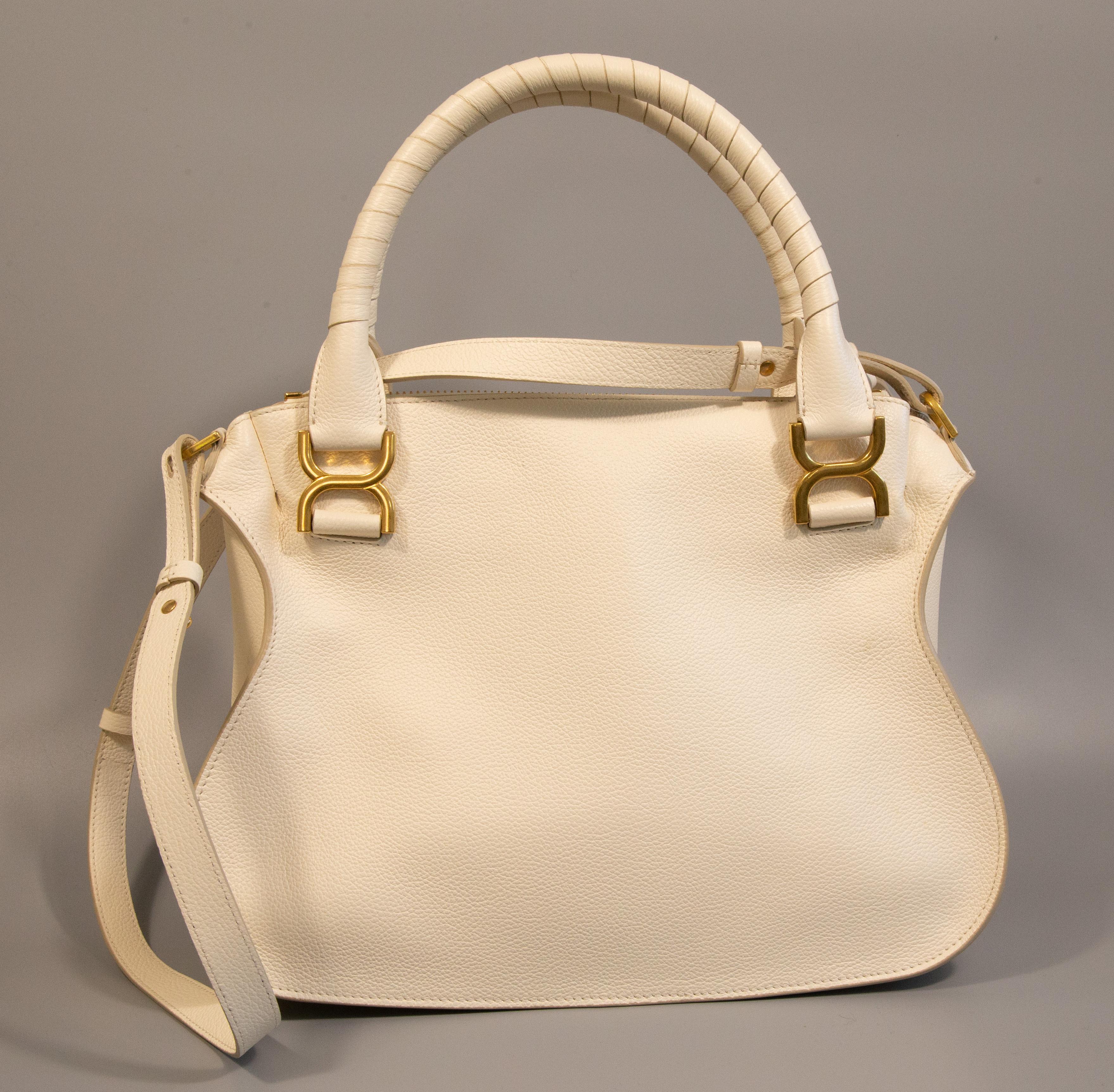 Chloe Marcie medium double carry bag in Misty Ivory. The bag is made of leather with gold toned hardware. It is lined with beige fabric, and next to the major compartment it features one side pocket with a zipper. 
The item seems to be unworn and it