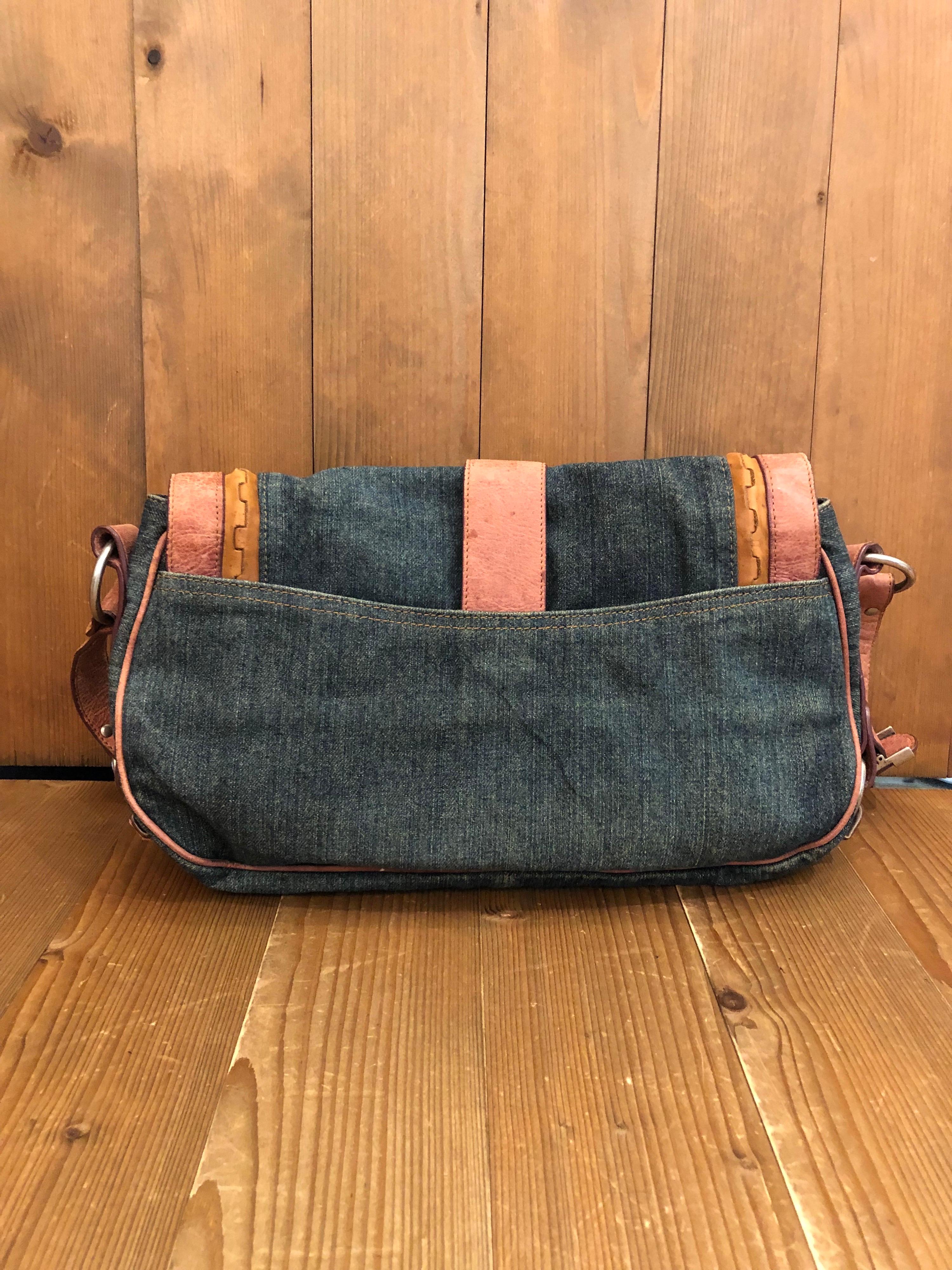 This vintage 2000s Christian Dior Gaucho Saddle shoulder bag is crafted of blue denim and brown leather featuring one interior zippered pocket and one back open pocket. Made in Italy. Measures 13 x 9 x 3.5 Strap drop 11 inches. 

Condition: Signs of